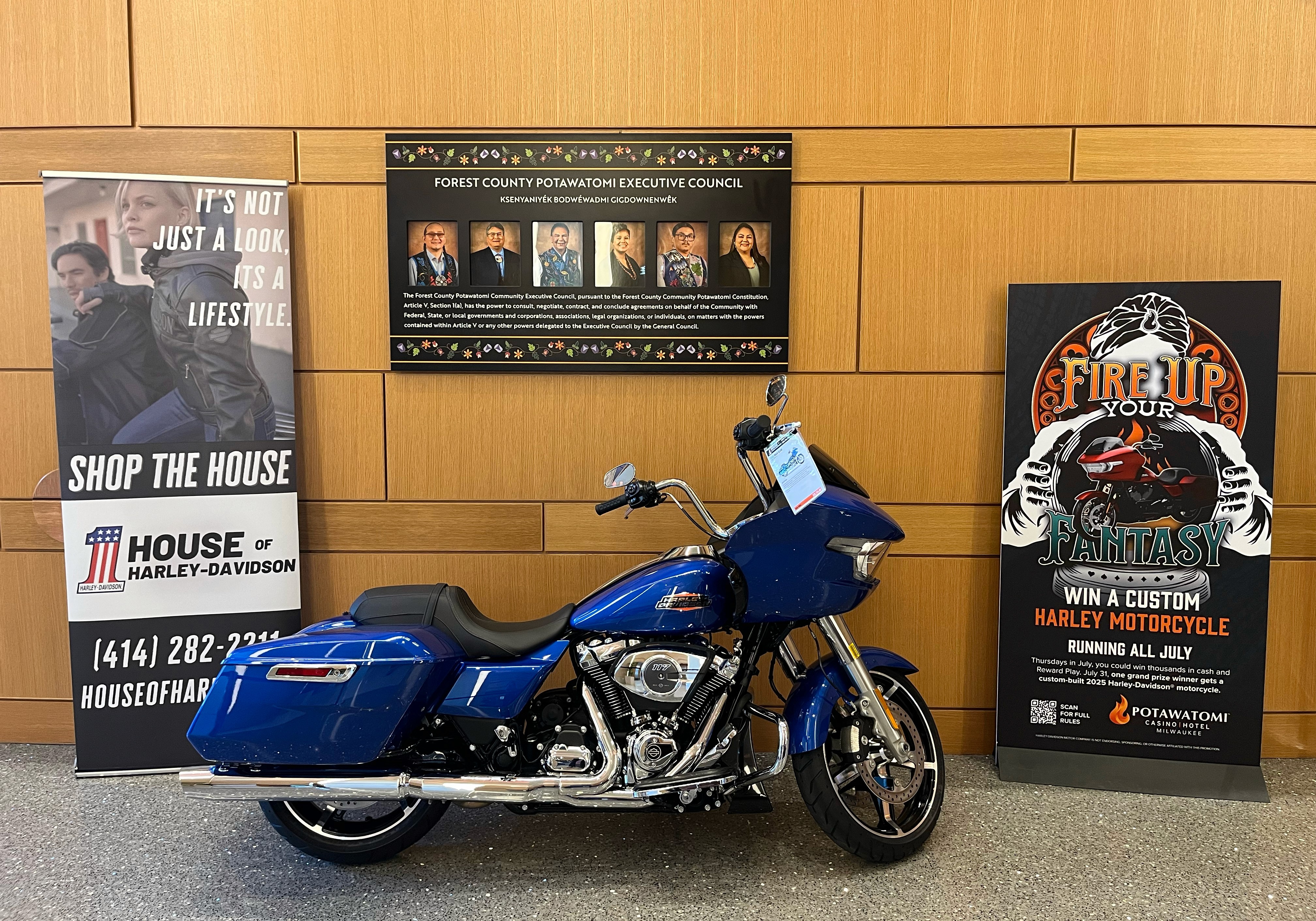 Photo of a Harley-Davidson motorcycle next to a "Fire Up Your Fantasy" standee
