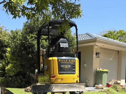 Mini excavator trenching a backyard for services, Sunshine Coast