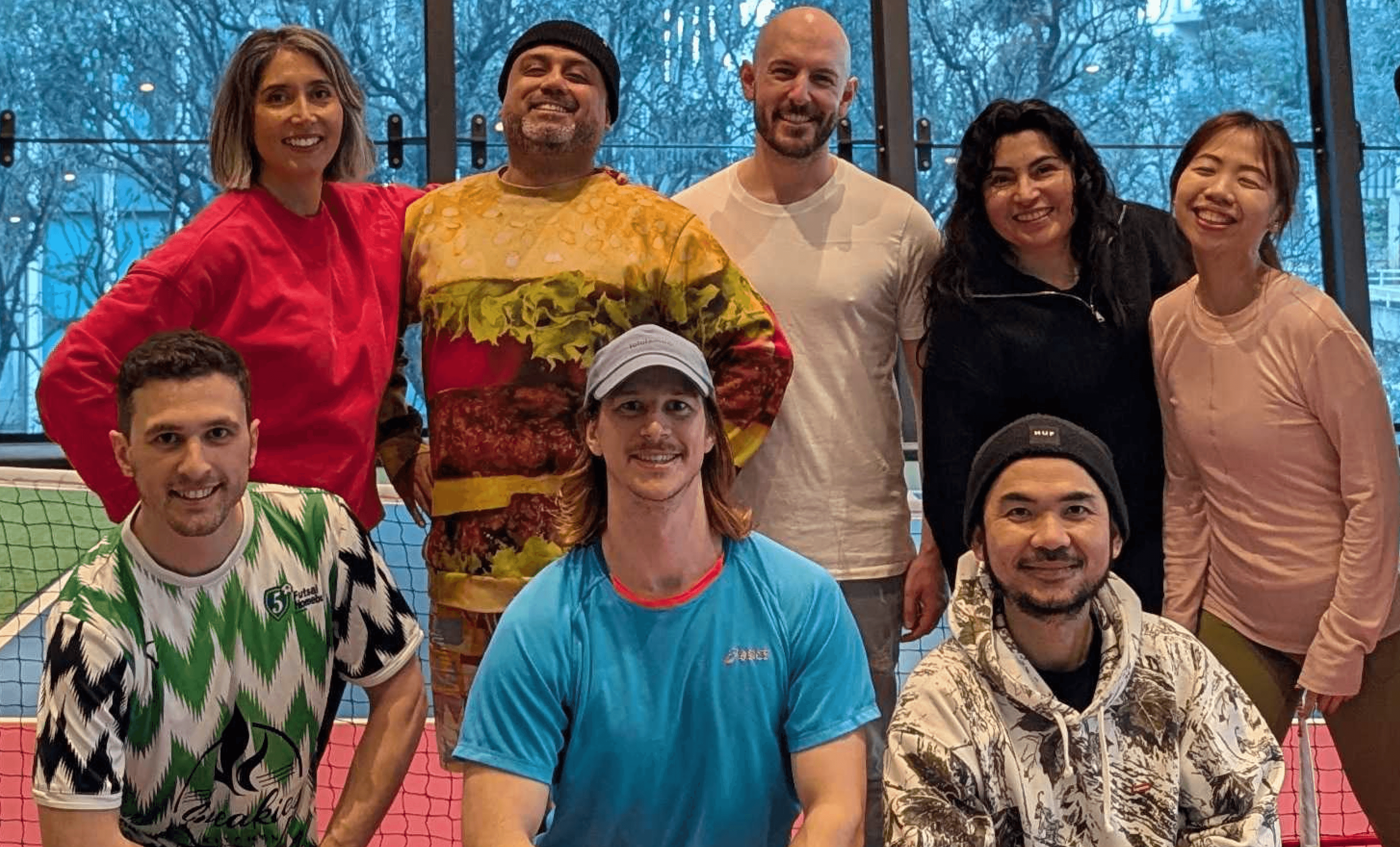 Black and white image of people working at a table with laptops, showing hands gesturing during discussion of digital content displayed on screens, with fabrica® logo in the corner.
