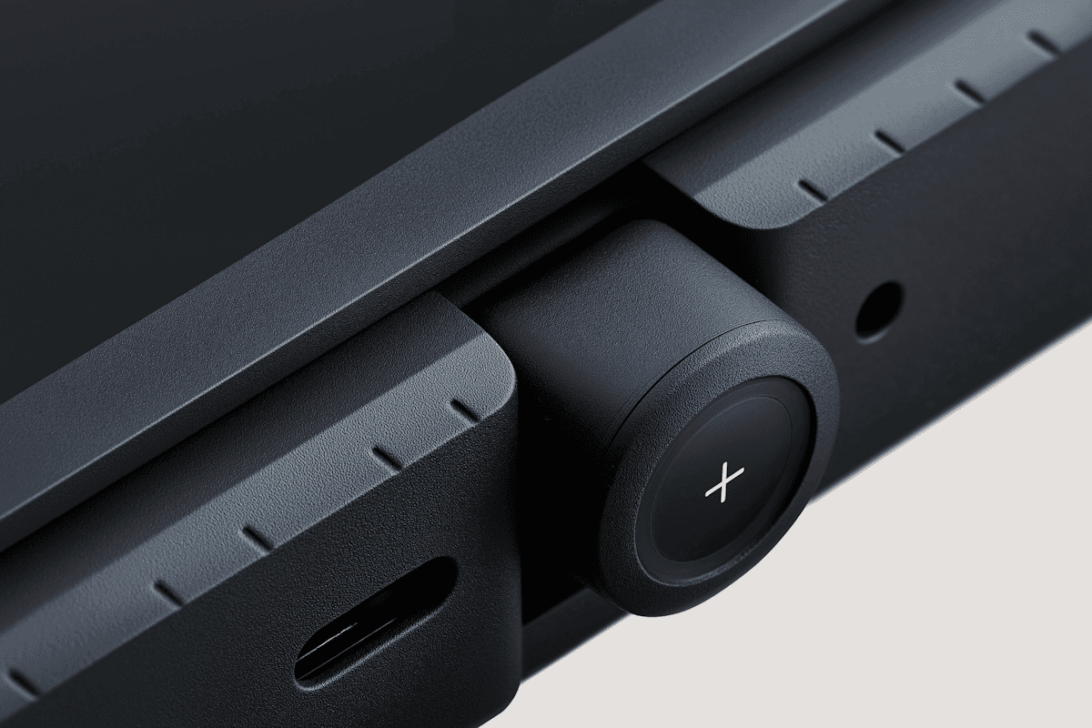 Close-up of a matte black device featuring a tactile rotating dial with a plus symbol, positioned between two ridged edges and next to a USB-C port.