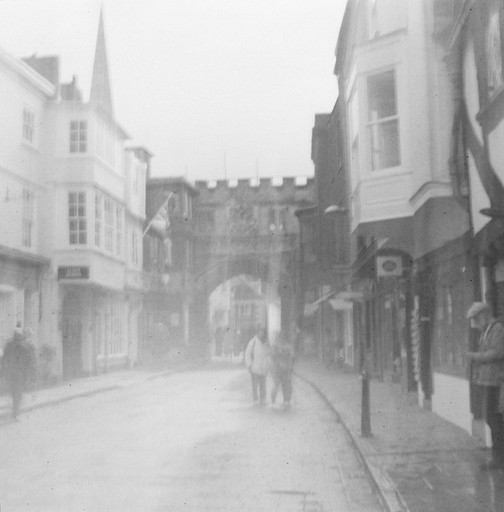 Street scene with buildings and people in fog.