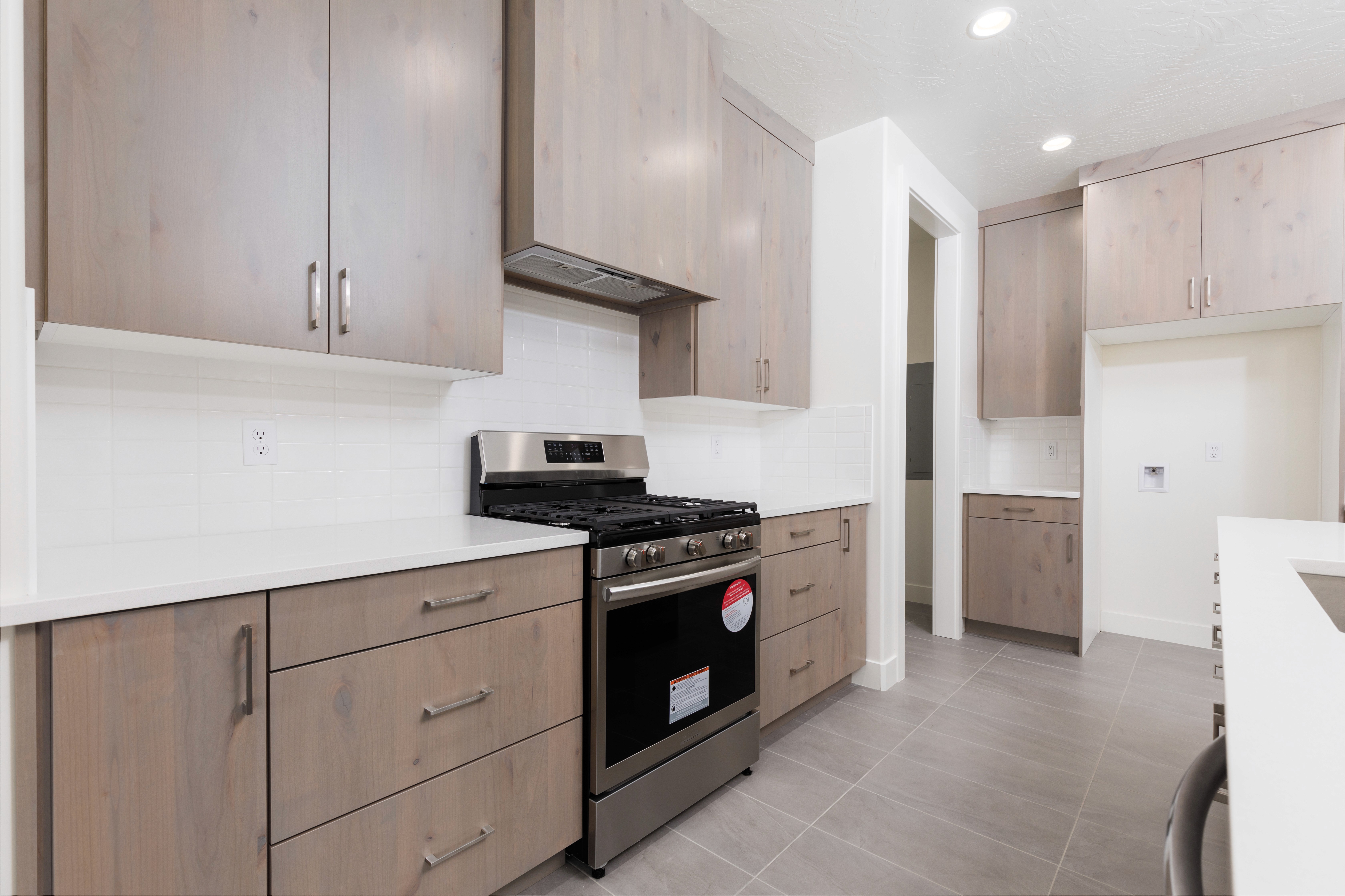 Kitchen island and wood cabinets in Mountain View’s Cove highlighting warm finishes and functional design in a Southern Utah home.