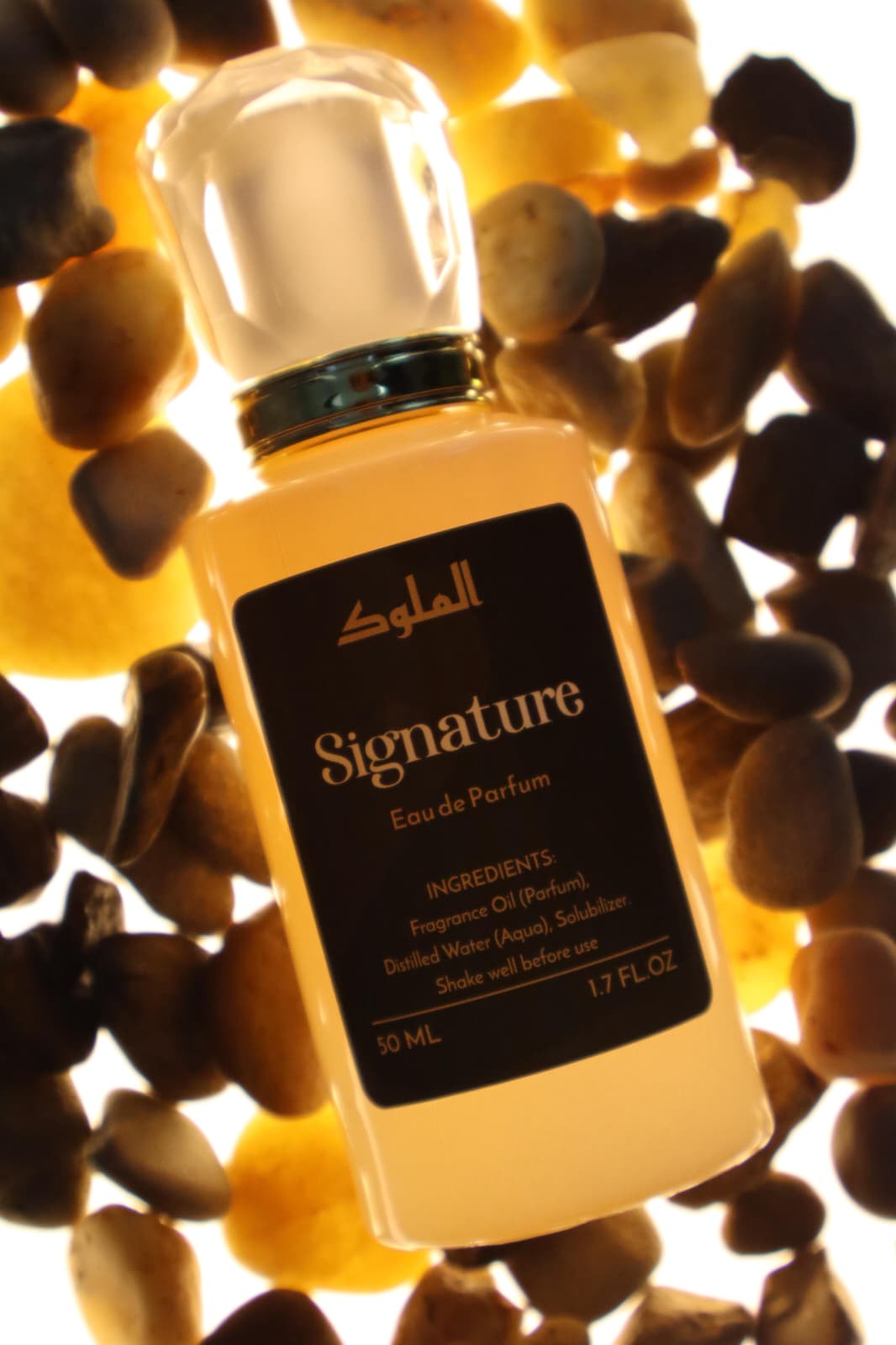 Al-Mulook amber-toned product packaging with gold logo photographed in warm, dramatic lighting.