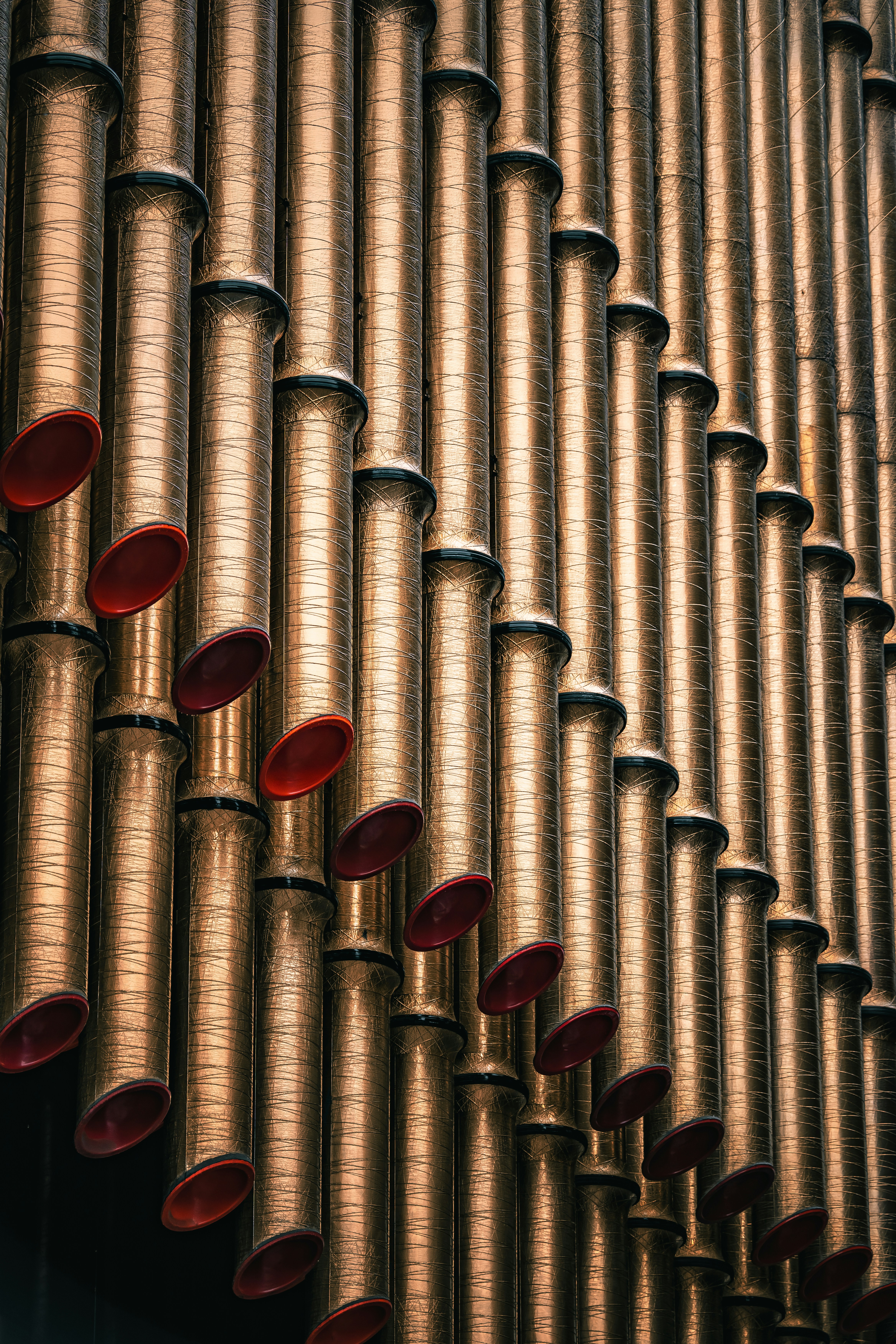 Close-up of golden organ pipes with red accents