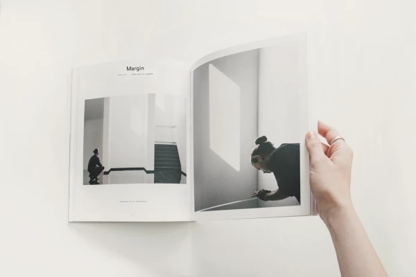 Hand holding an open magazine spread