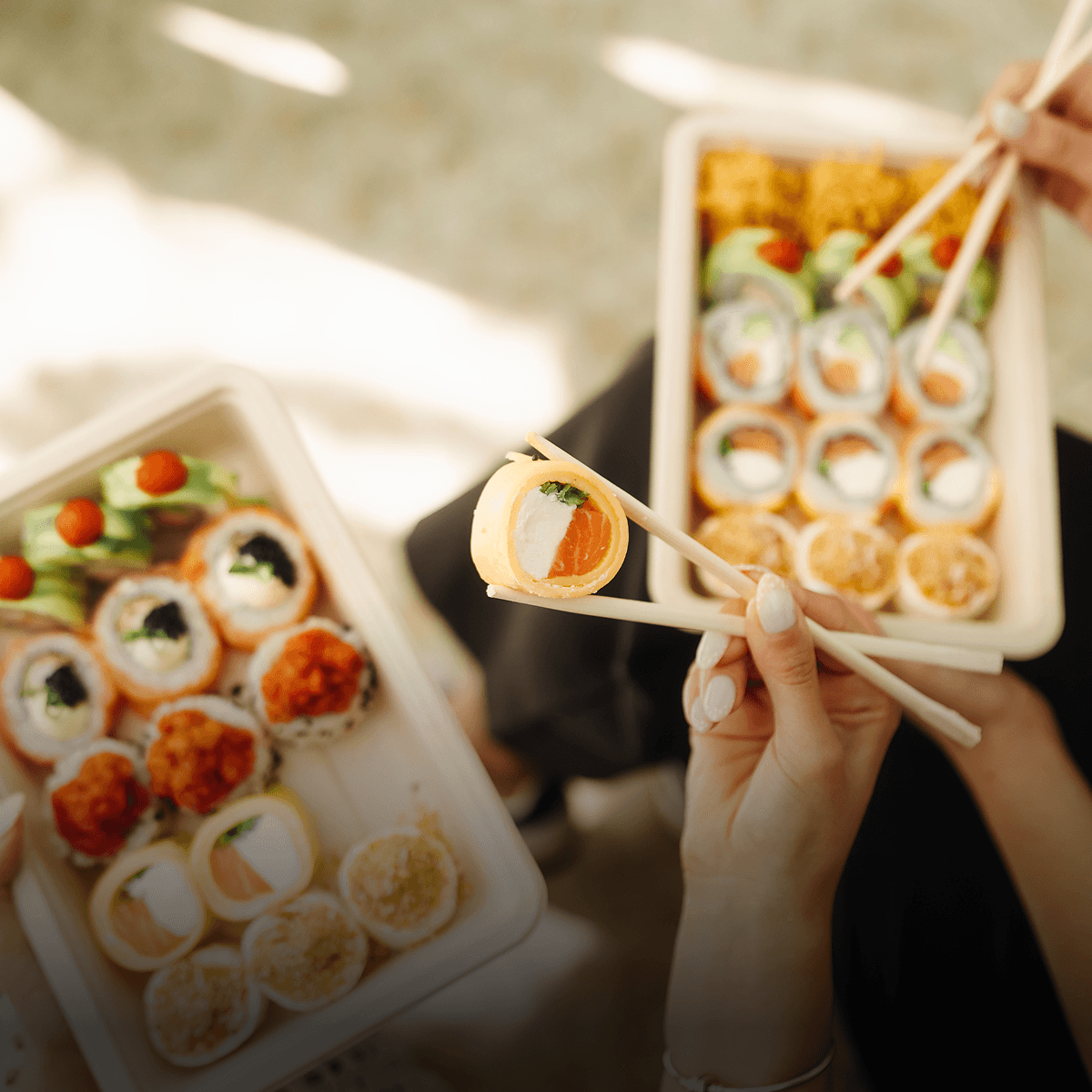 Roll de sushi agarrado con palillos.