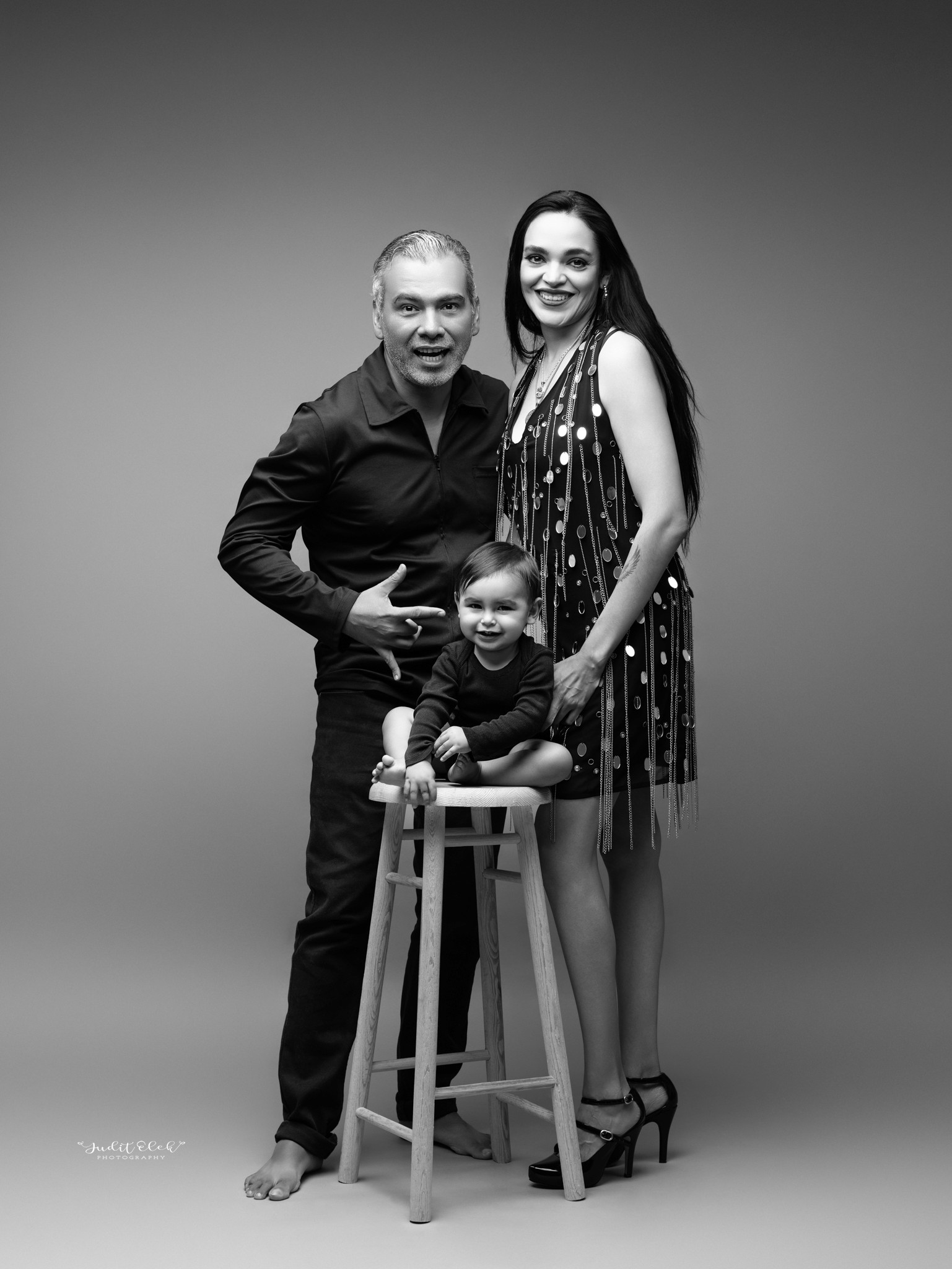 niño riendo con sus papás en una sesión de fotos en estudio fotográfico