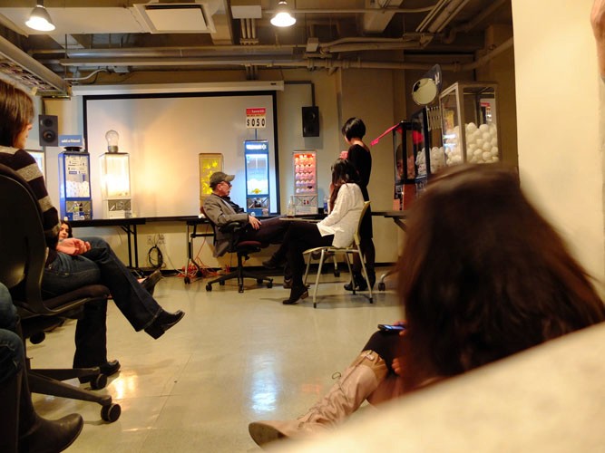 A photo of several people sitting on chairs and talking to each other.