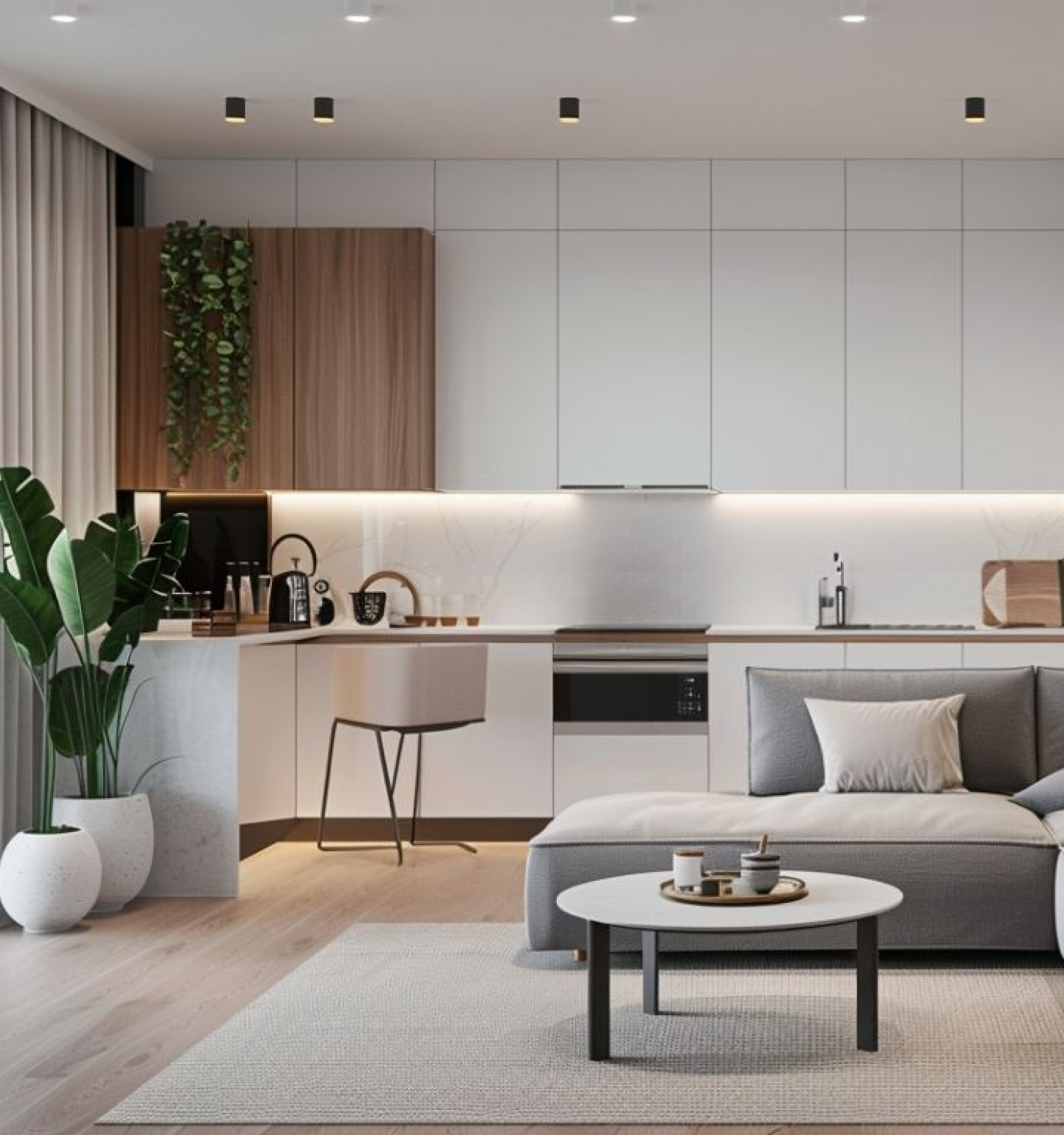 Nowoczesny salon połączony z aneksem kuchennym, wyposażony w białe szafki, jasny blat i szarą sofę z okrągłym stolikiem kawowym. Na środku widoczna etykieta z ofertą: 'od 1290 zł za mkw – Od projekt + materiały + wykończenie'.