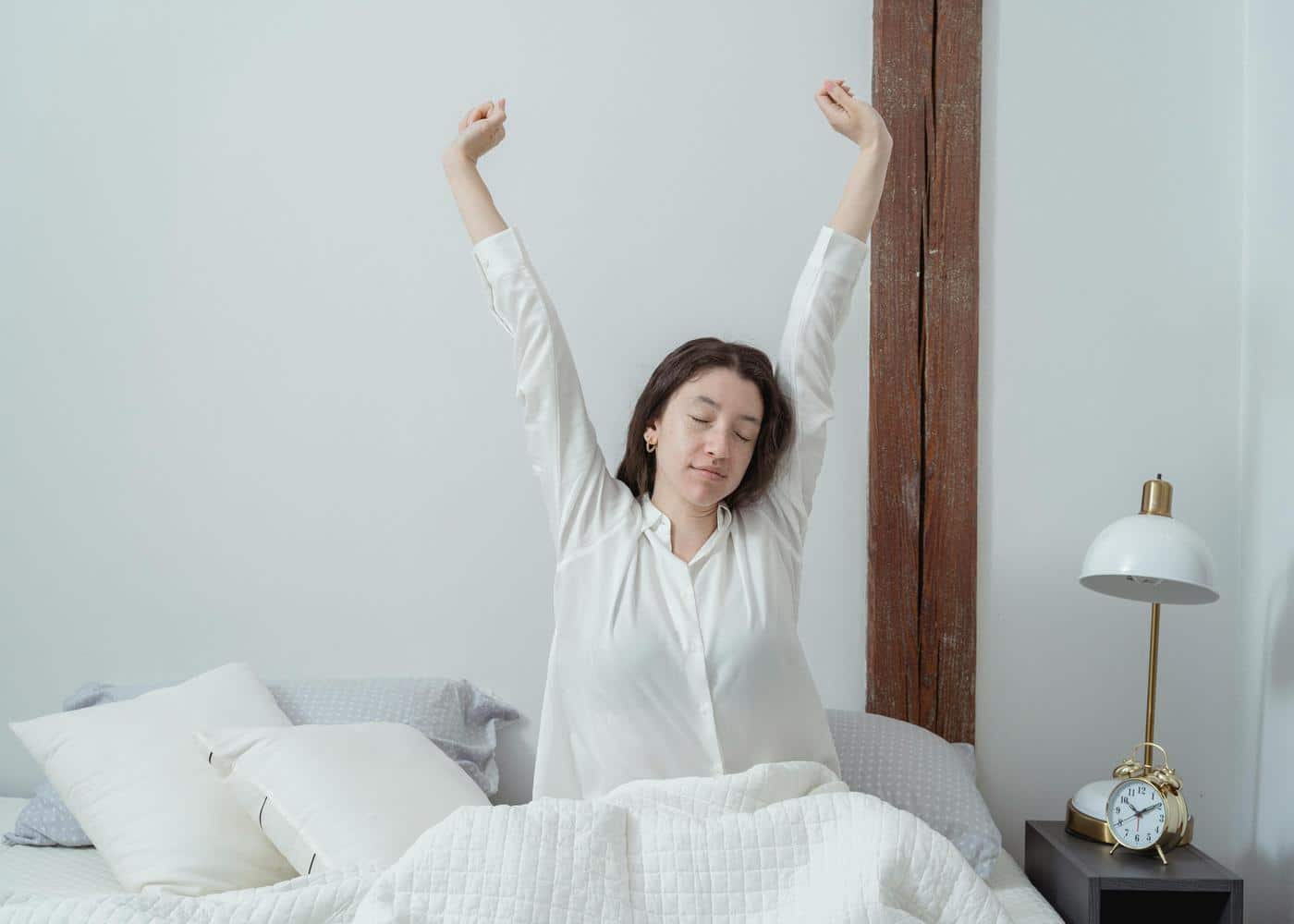 Woman representing early birds waking up and stretching her arms