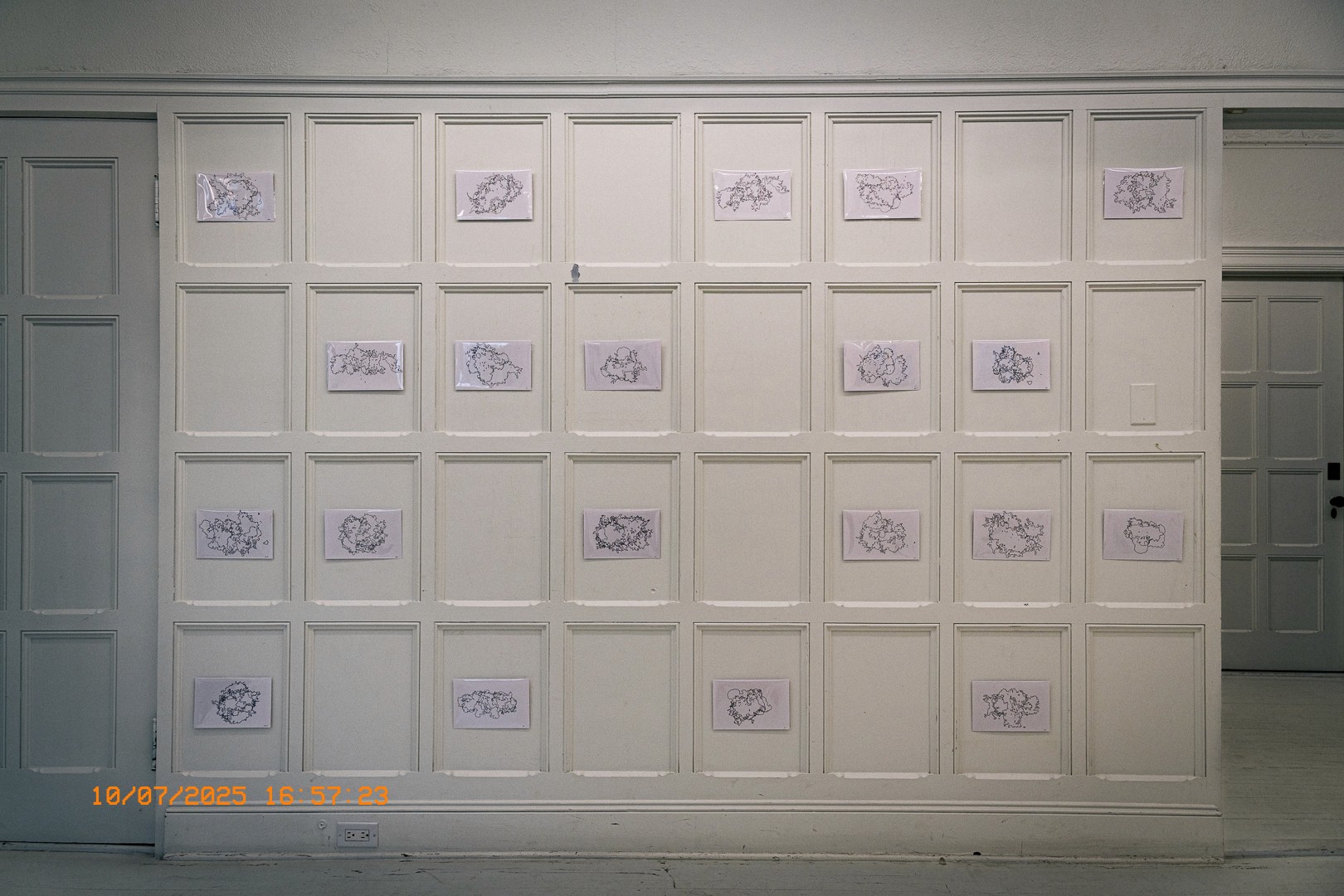  Mur d’exposition du Livart avec des dessins cartographiques encadrés.