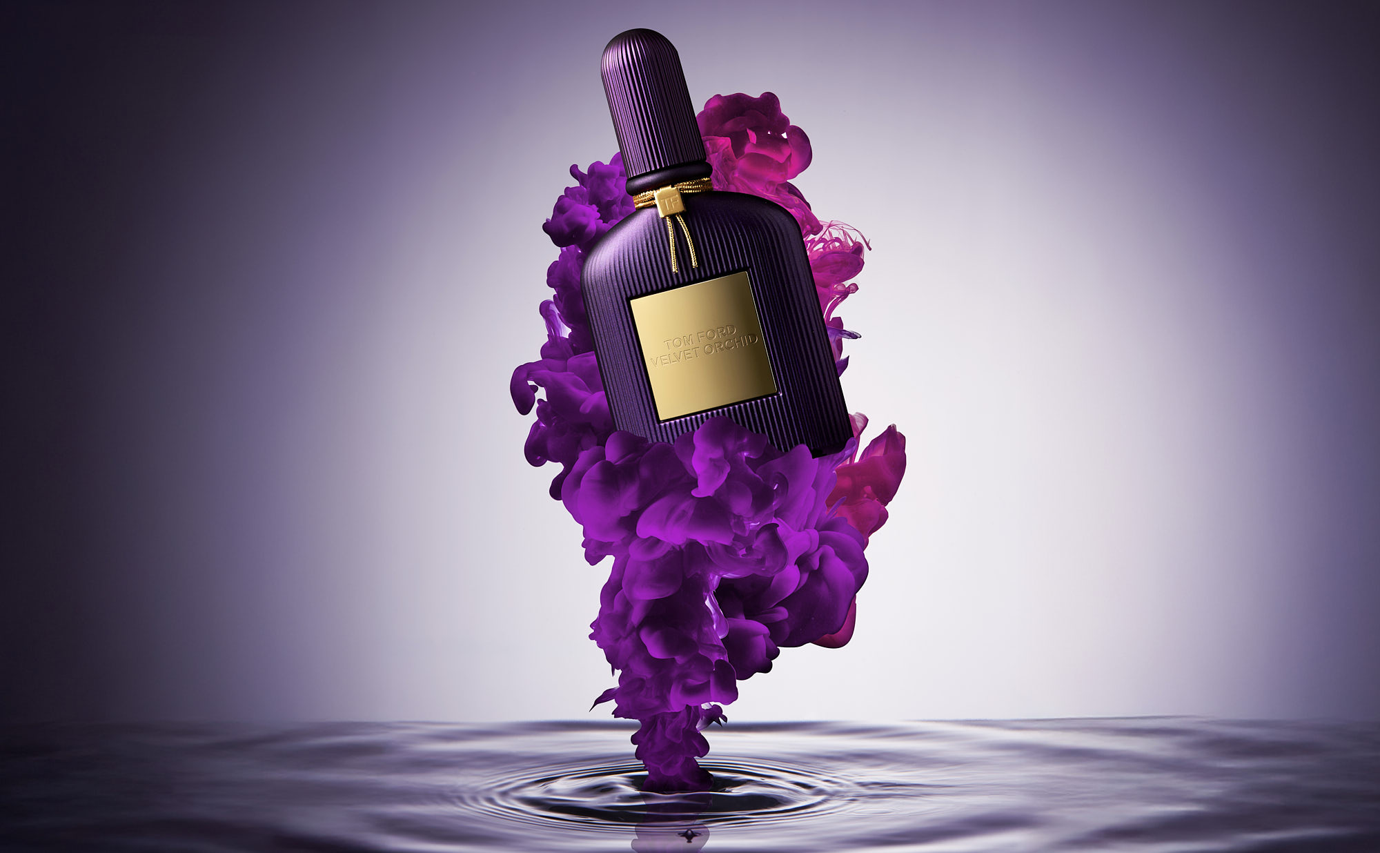 A bottle of perfume surrounded by vibrant purple burst of colour against a soft, neutral background.