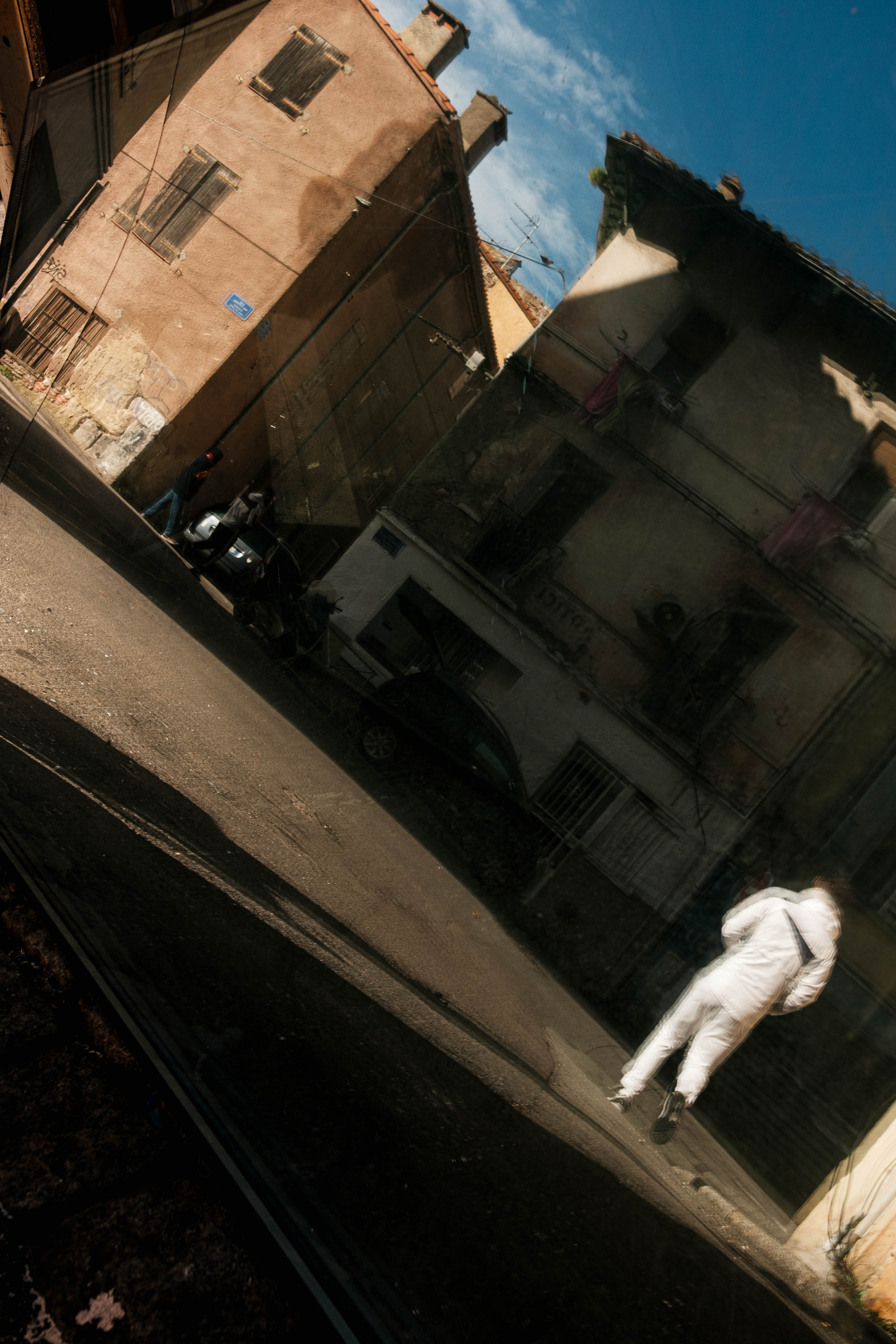 Reflection of a man in a piece of glass in the street