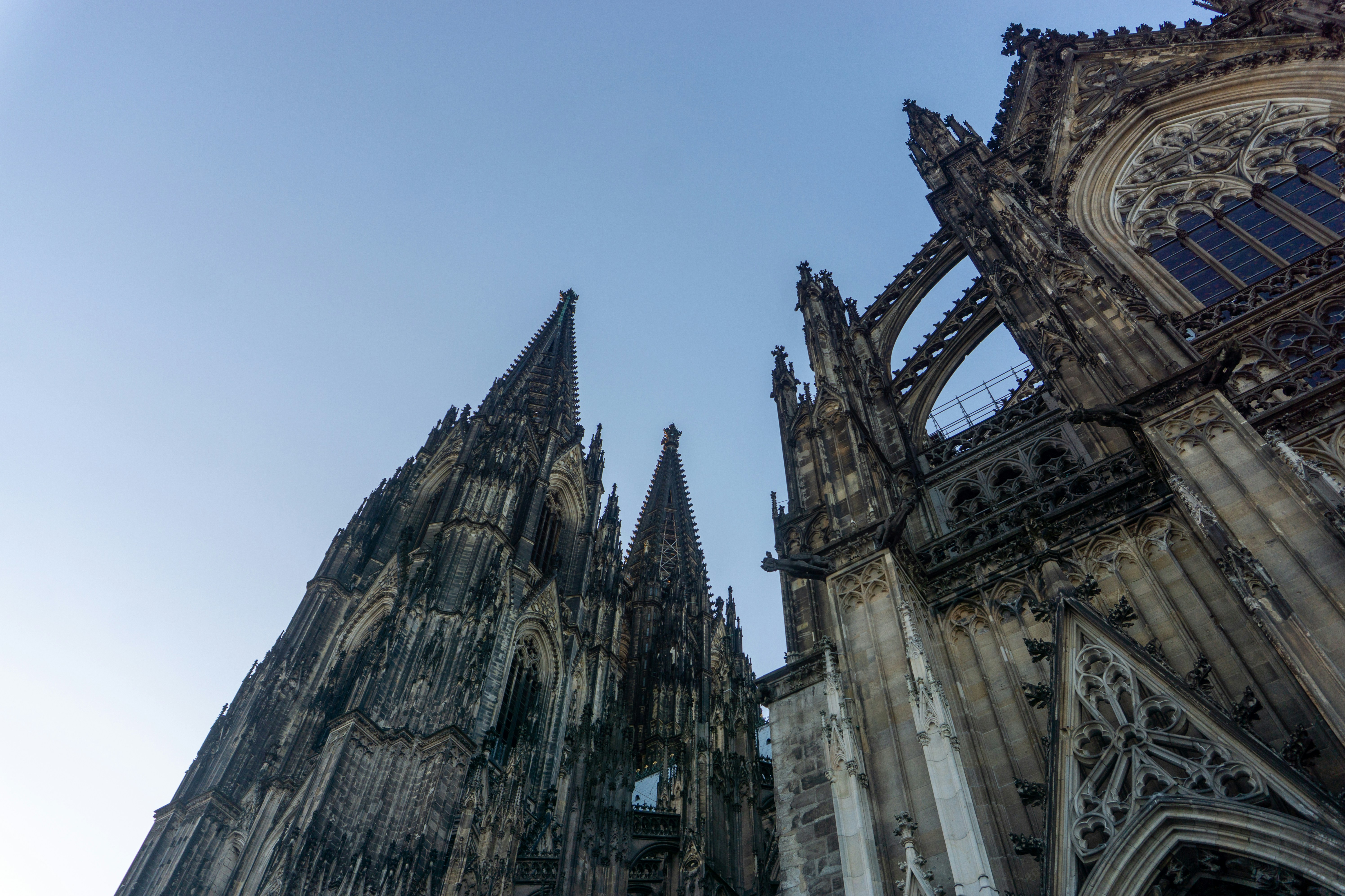 Gothic cathedral spires reaching towards a clear blue sky.