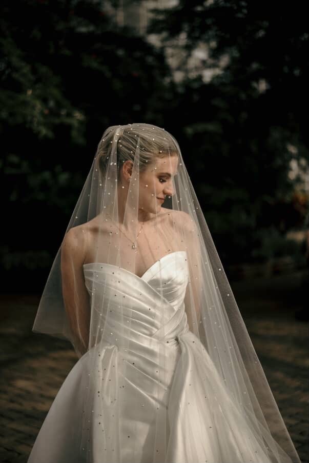 Bold editorial fashion portrait of model in houndstooth blazer with red tie and green shirt against bright turquoise background - Serif Creative Studio luxury fashion photography