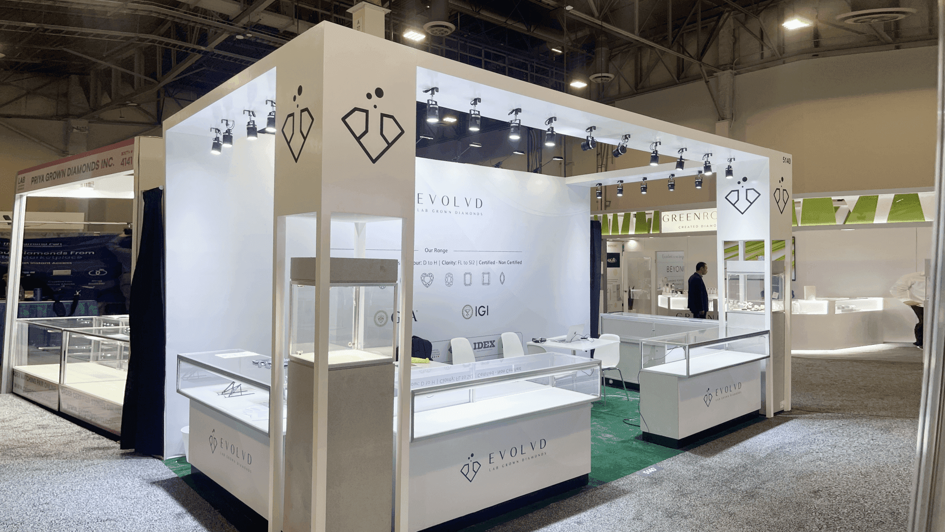 Evolvd JCK Las Vegas 2023 10x20 jewelry showcase booth with illuminated overhead frame, glass display counters, branded wall graphics, and open consultation area