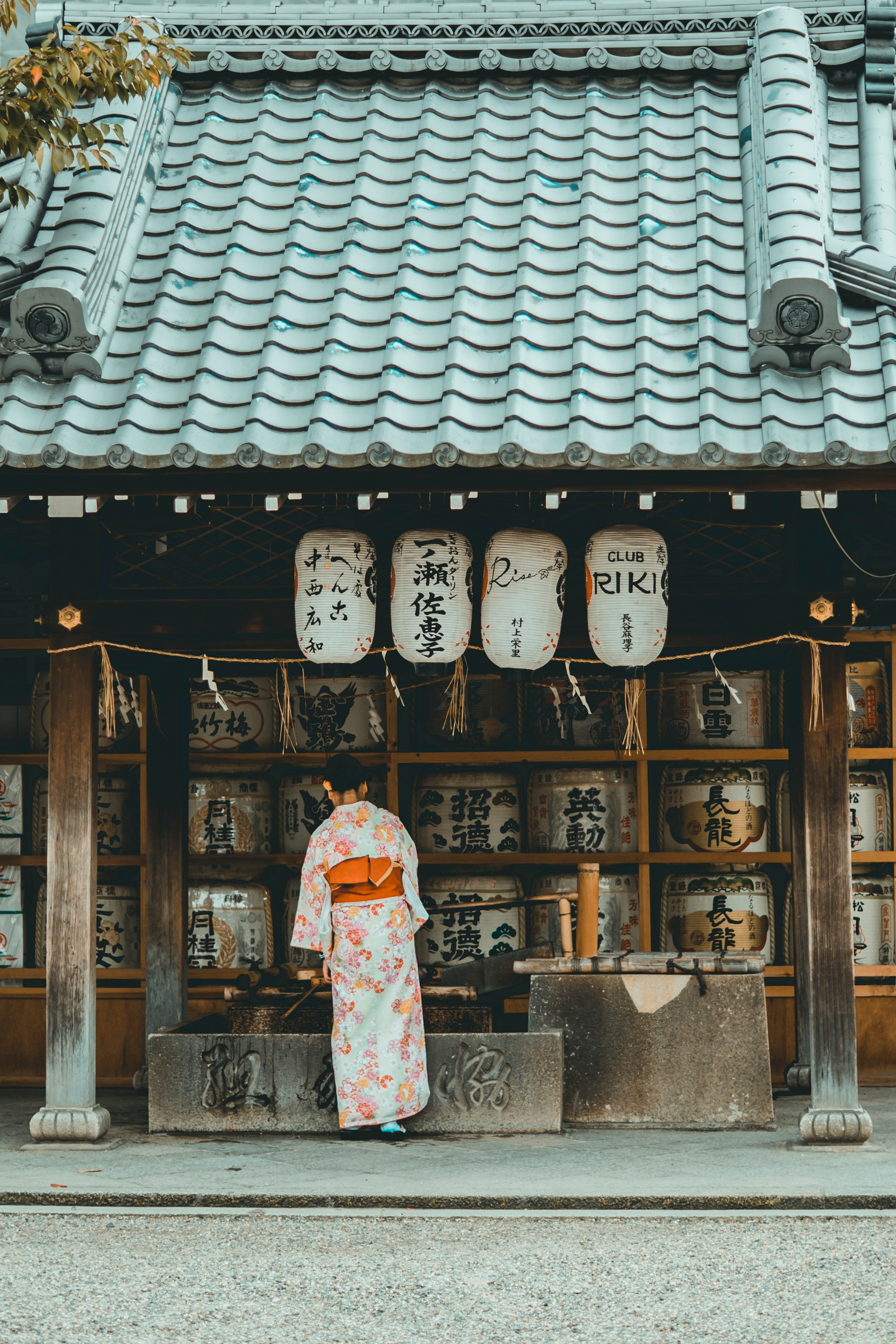 woman wearing orange and white kimono dress standing near the house