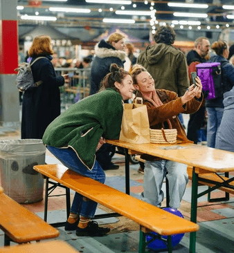 two women laughing whilst taking a selfie in sit down area at free from festival