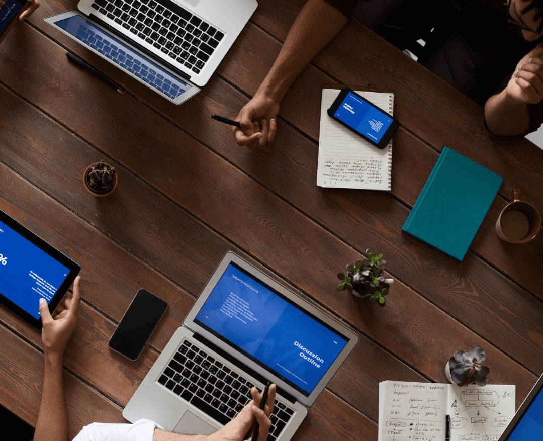 person holding pencil near laptop computer