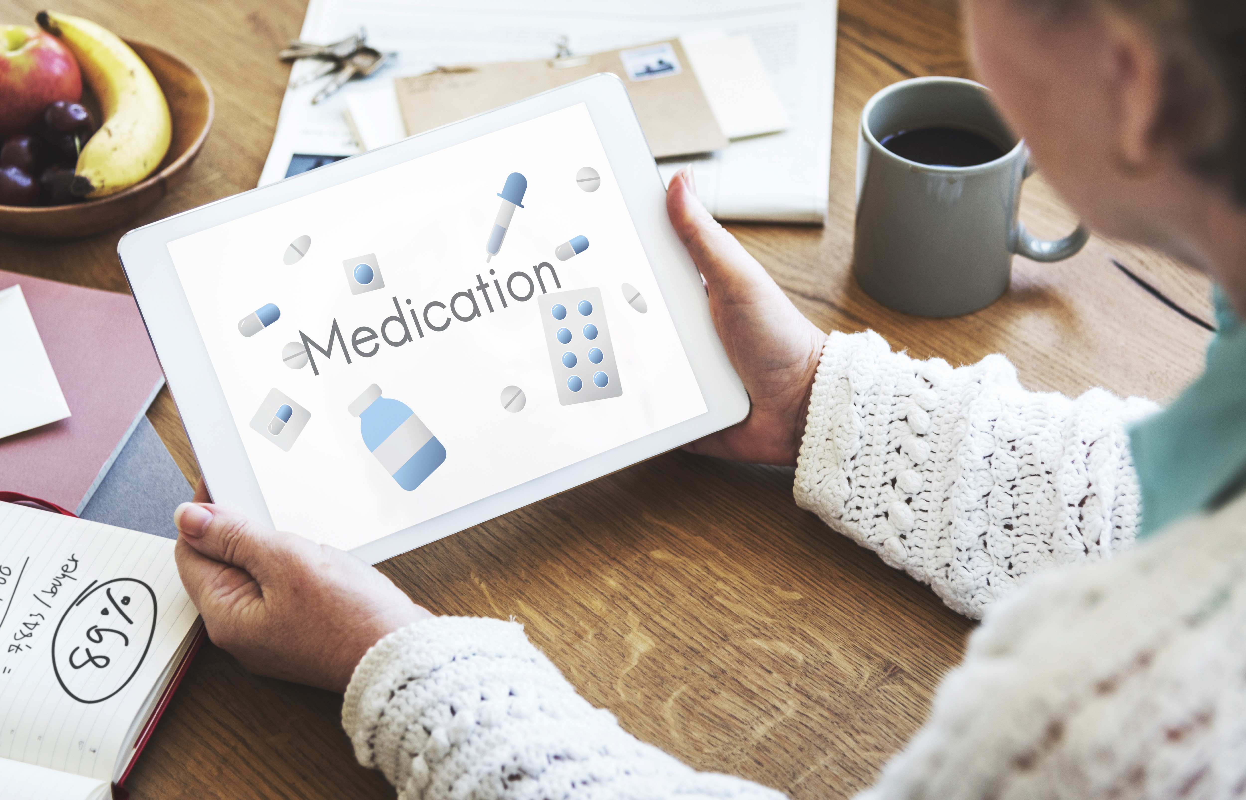 A person using a tablet with a "Medication" graphic, symbolizing modern healthcare and digital solutions.