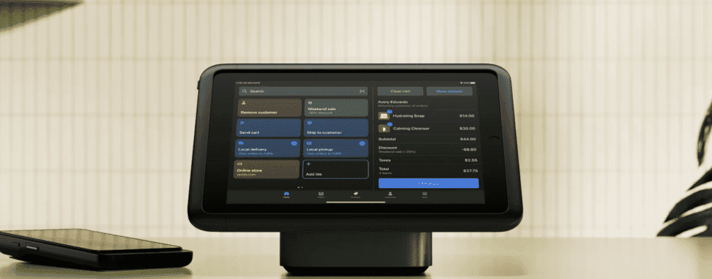 Tablet running a point of sale checkout screen on a countertop stand, illustrating Shopify POS