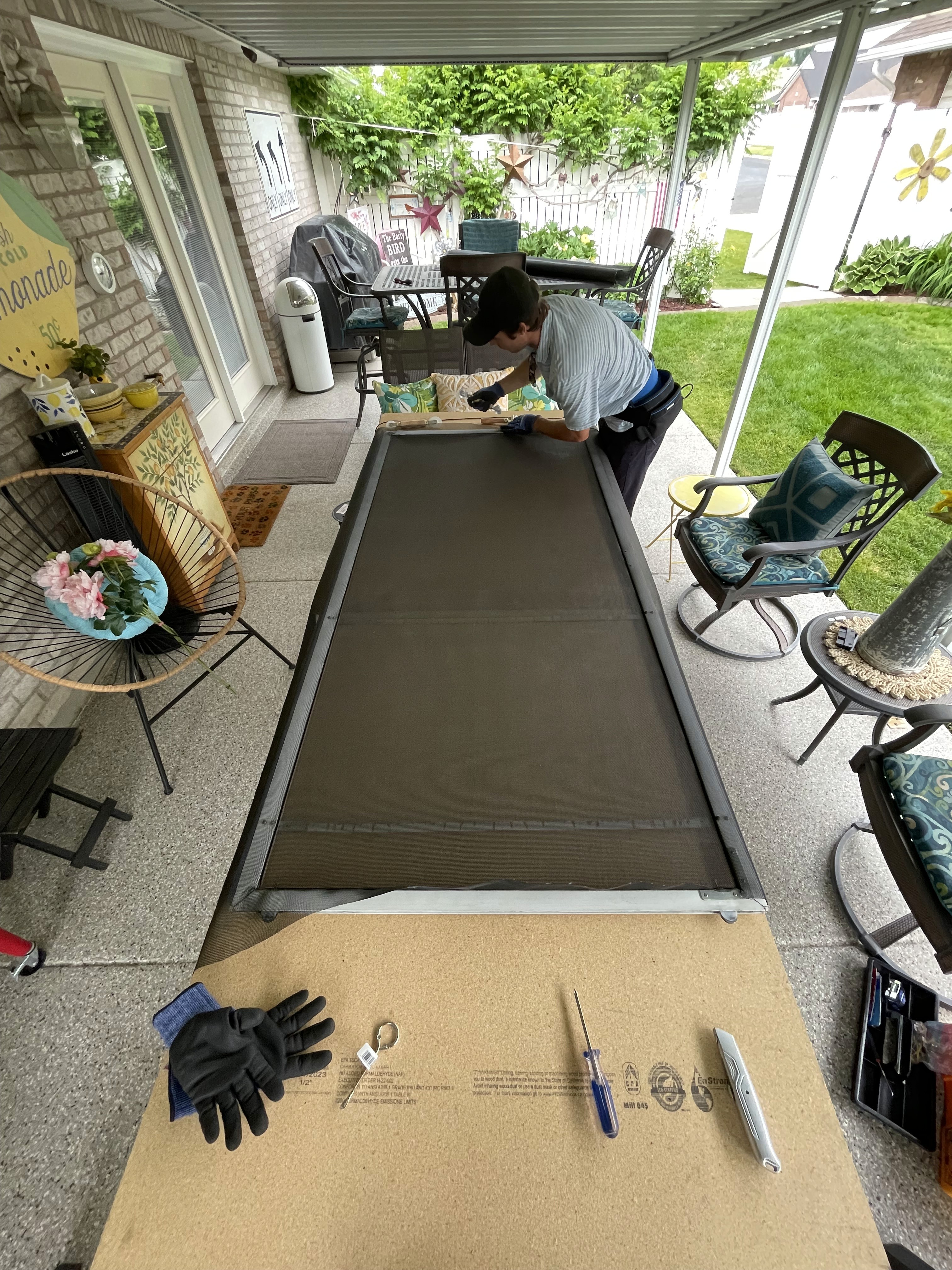 Technician repairing a sliding screen door in a residential home along wasatch front.