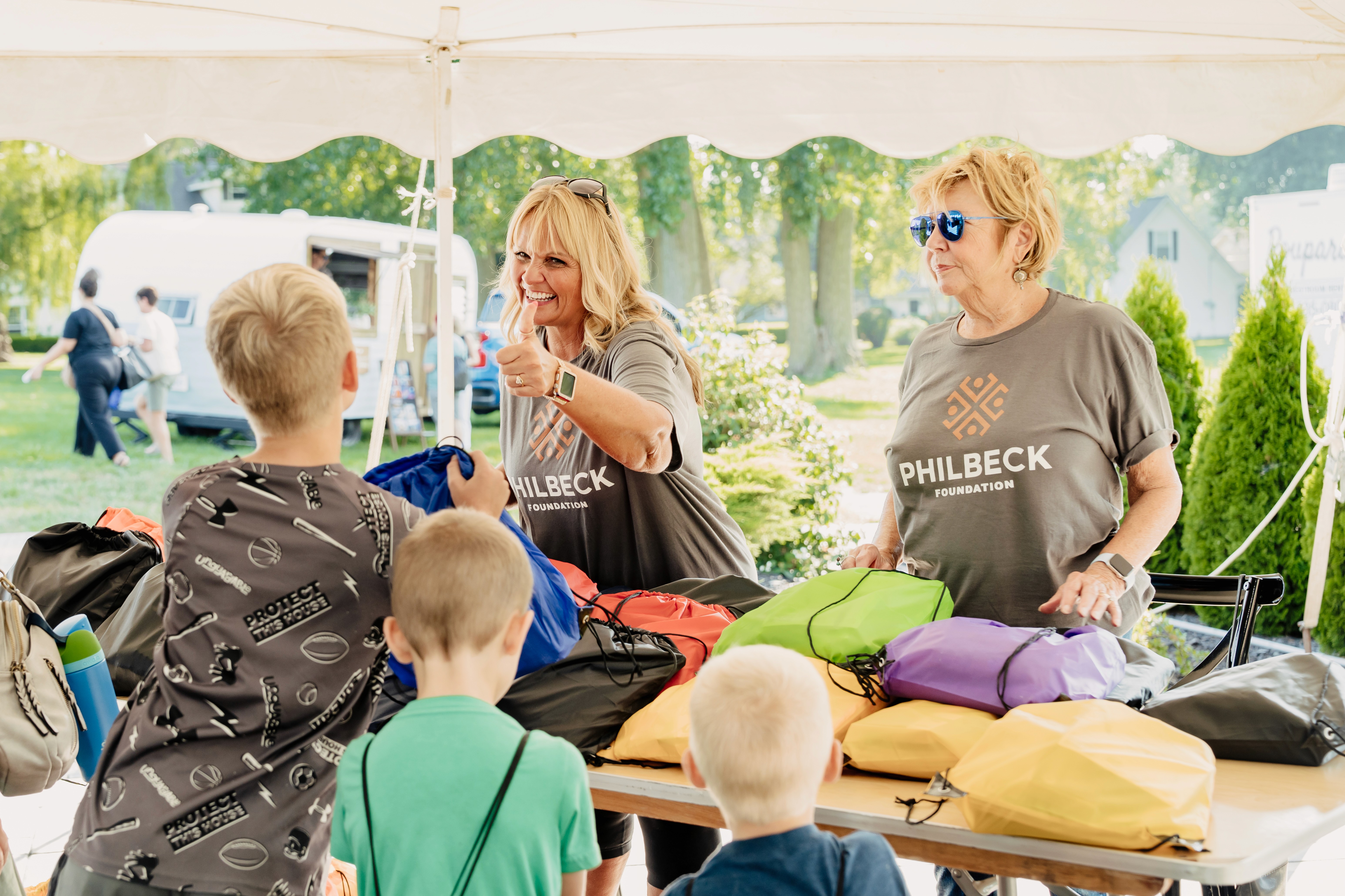 Three children jumping in burlap sacks during a race.