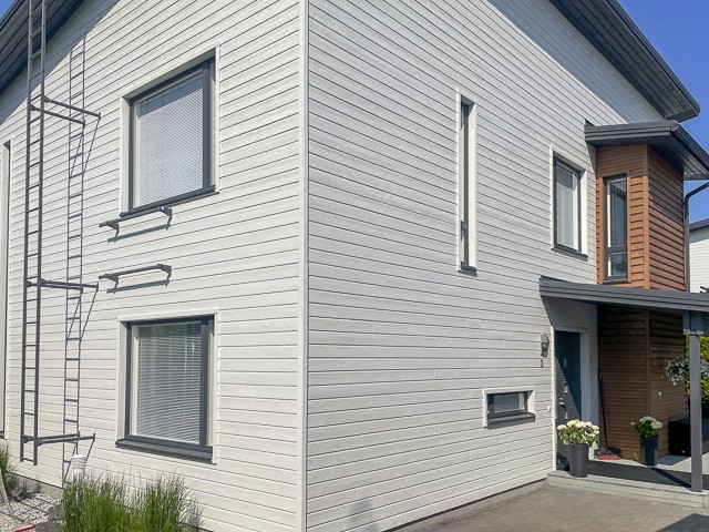 Ulkomaalattu moderni omakotitalo Seinäjoella, vaalea vaakaverhoilu, tyylikkäät tummat puuosat sisäänkäynnin yhteydessä, siisti ja nykyaikainen julkisivu