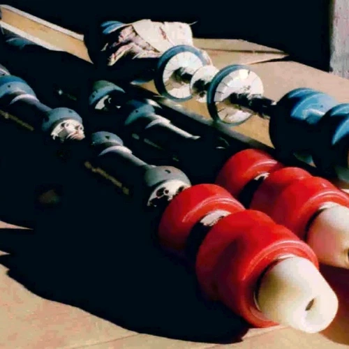Close-up of industrial machinery rollers in shades of blue and red, showing detailed construction and design.