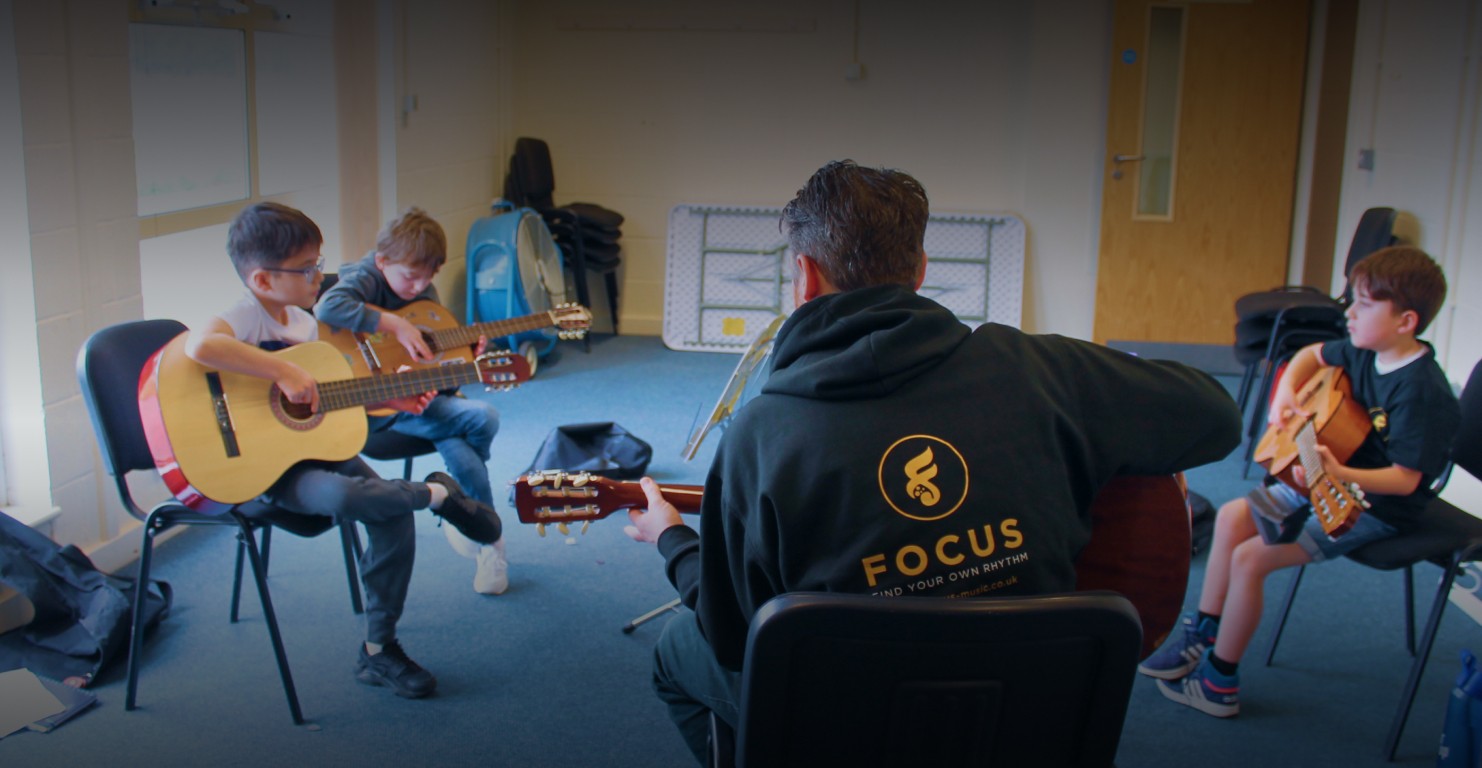 Students in the classroom learning guitar together