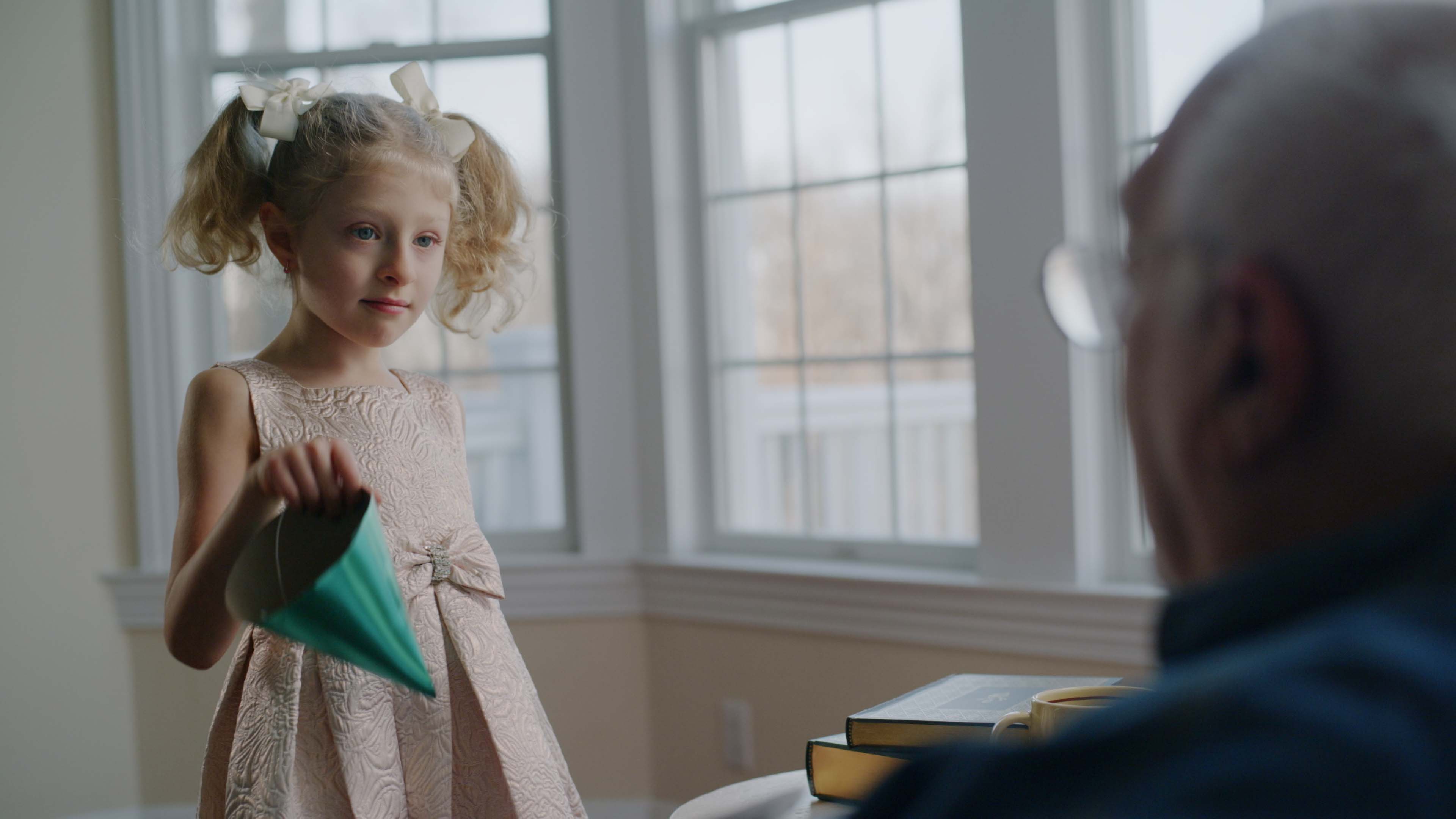 Front cover image for a short film made for Desert Dental. The image is of a little girl handing a party hat to her grandfather.