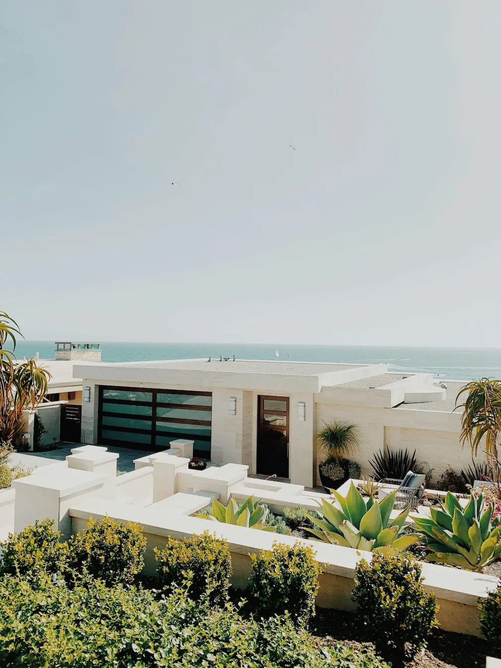 White residence next to the sea under a large white sky