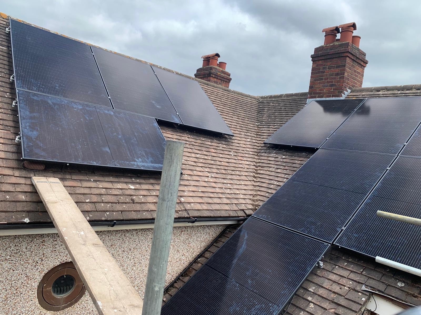 Solar panels installed across two roof faces either side of the chimney stacks at Nina's home