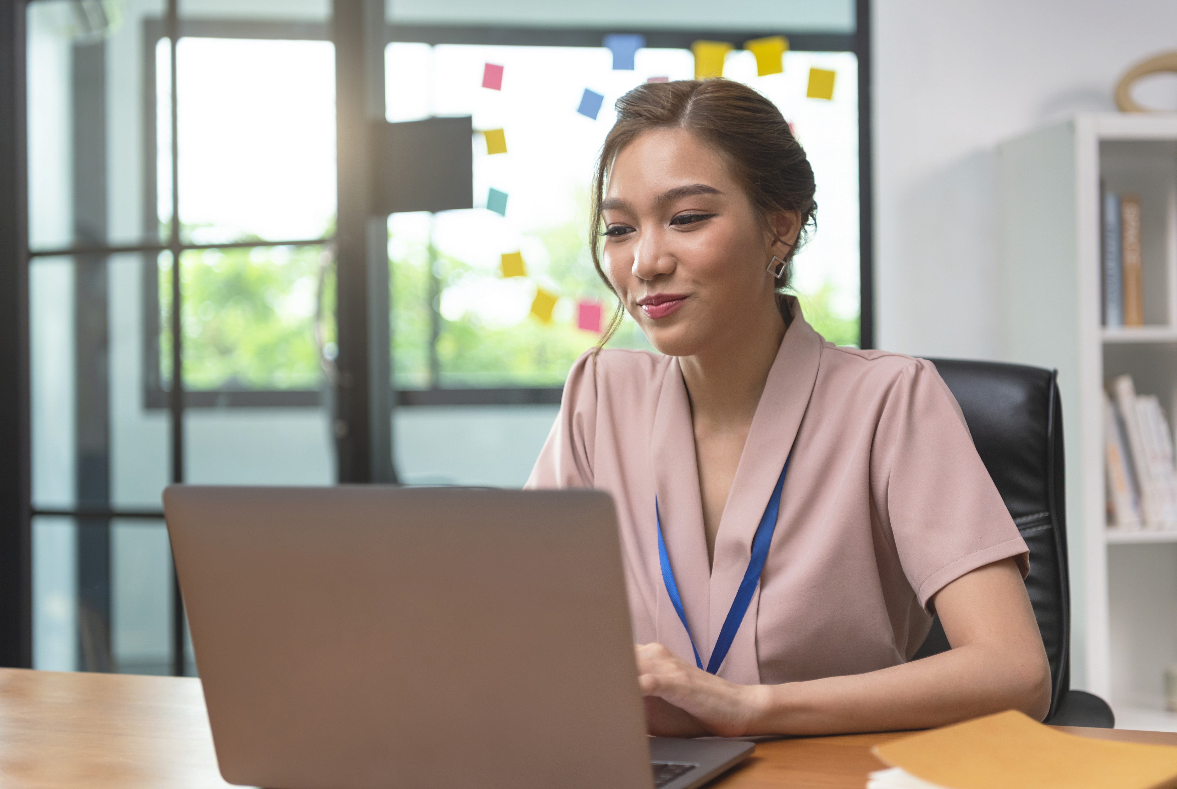 Asian businesswoman focused on her laptop in a modern office, embodying the shift to digital-first business strategies.