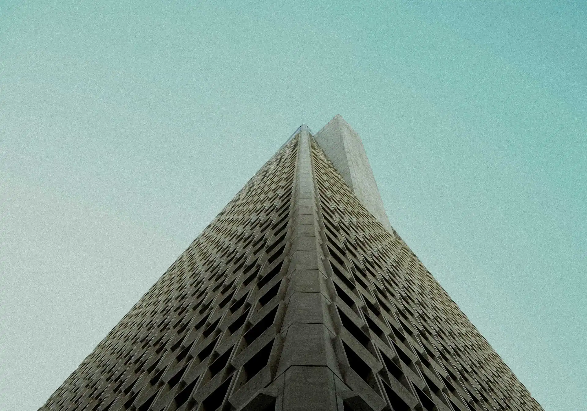 Low-angle view of a modern skyscraper with a geometric facade.