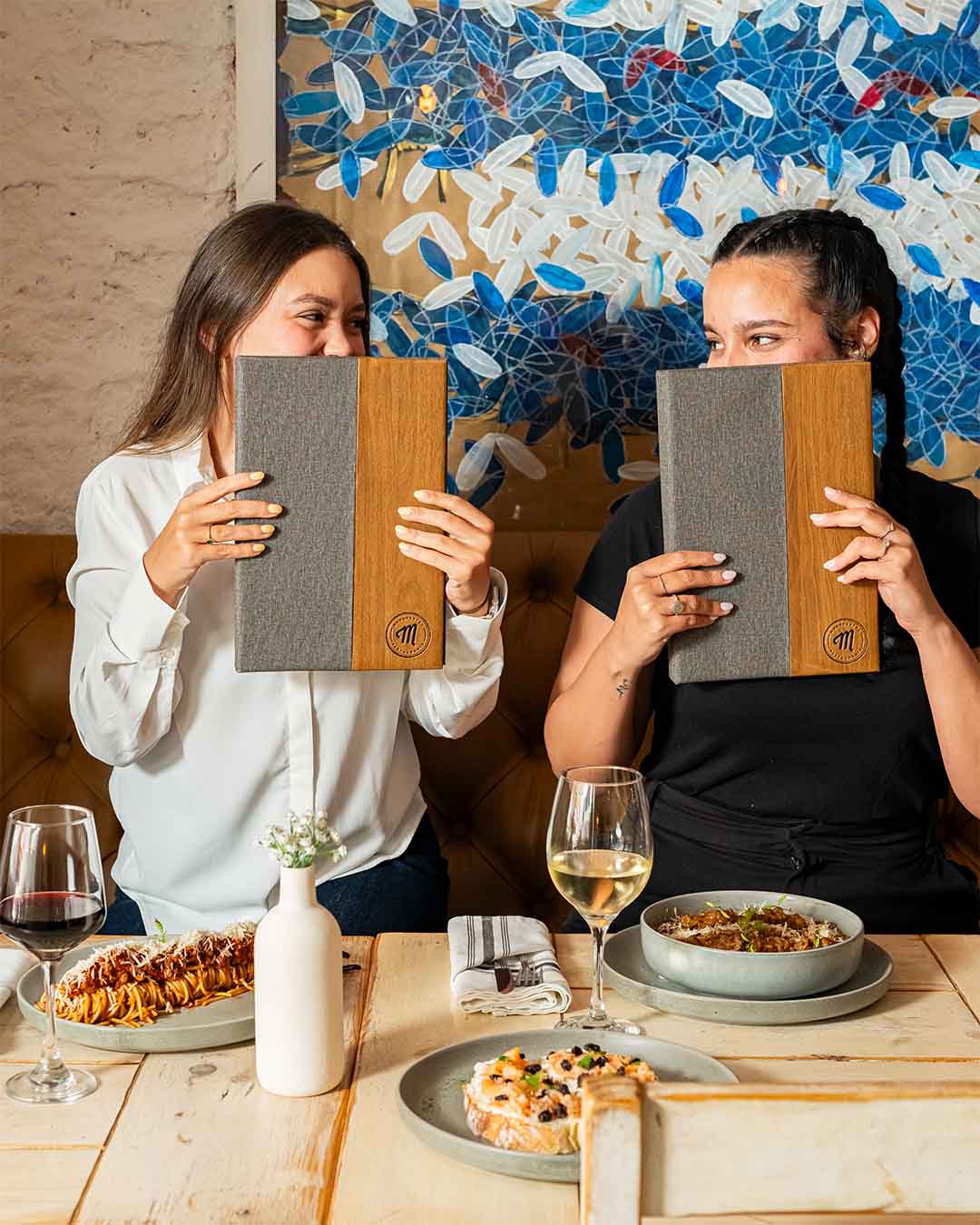Dos chicas sosteniendo menú de maradentro habana restaurante