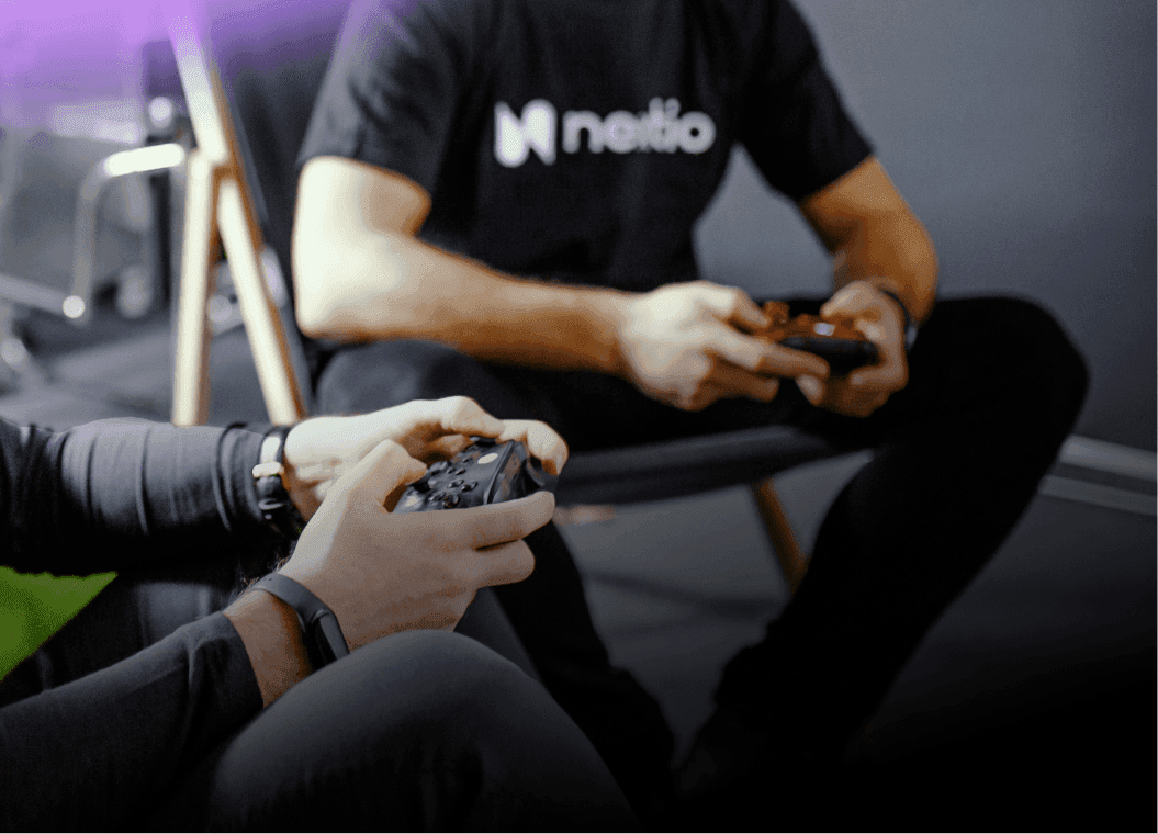 Nextio team members relaxing and playing video games in the office lounge area, showcasing the company's vibrant work culture.