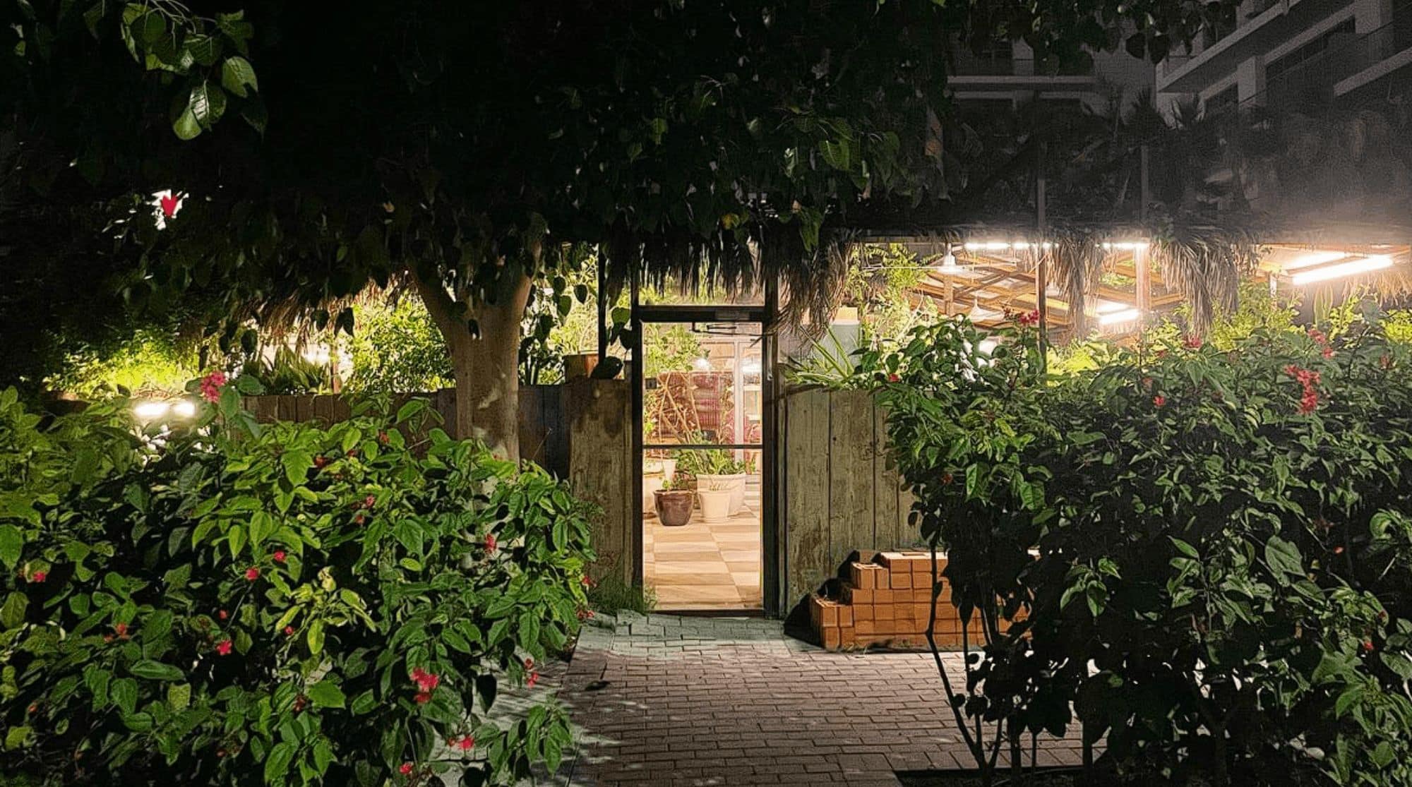 Maisan15 Cafe with greenery, paved walkways, and a clear entryway.