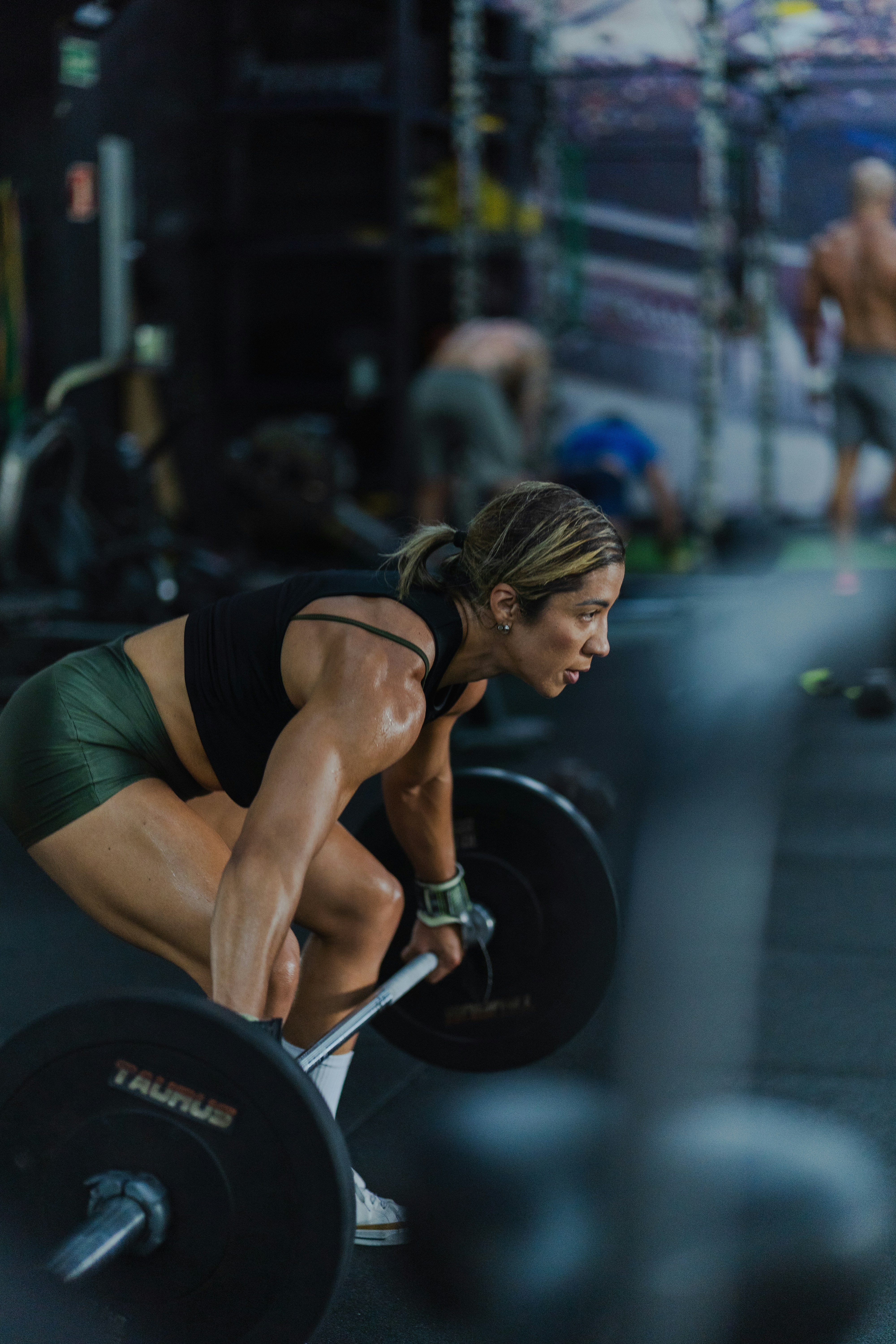 Woman lifting a heavy barbell in a gym