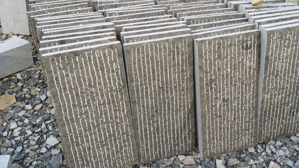 Rough-cut stone slabs stacked vertically, prepared for further processing or installation.