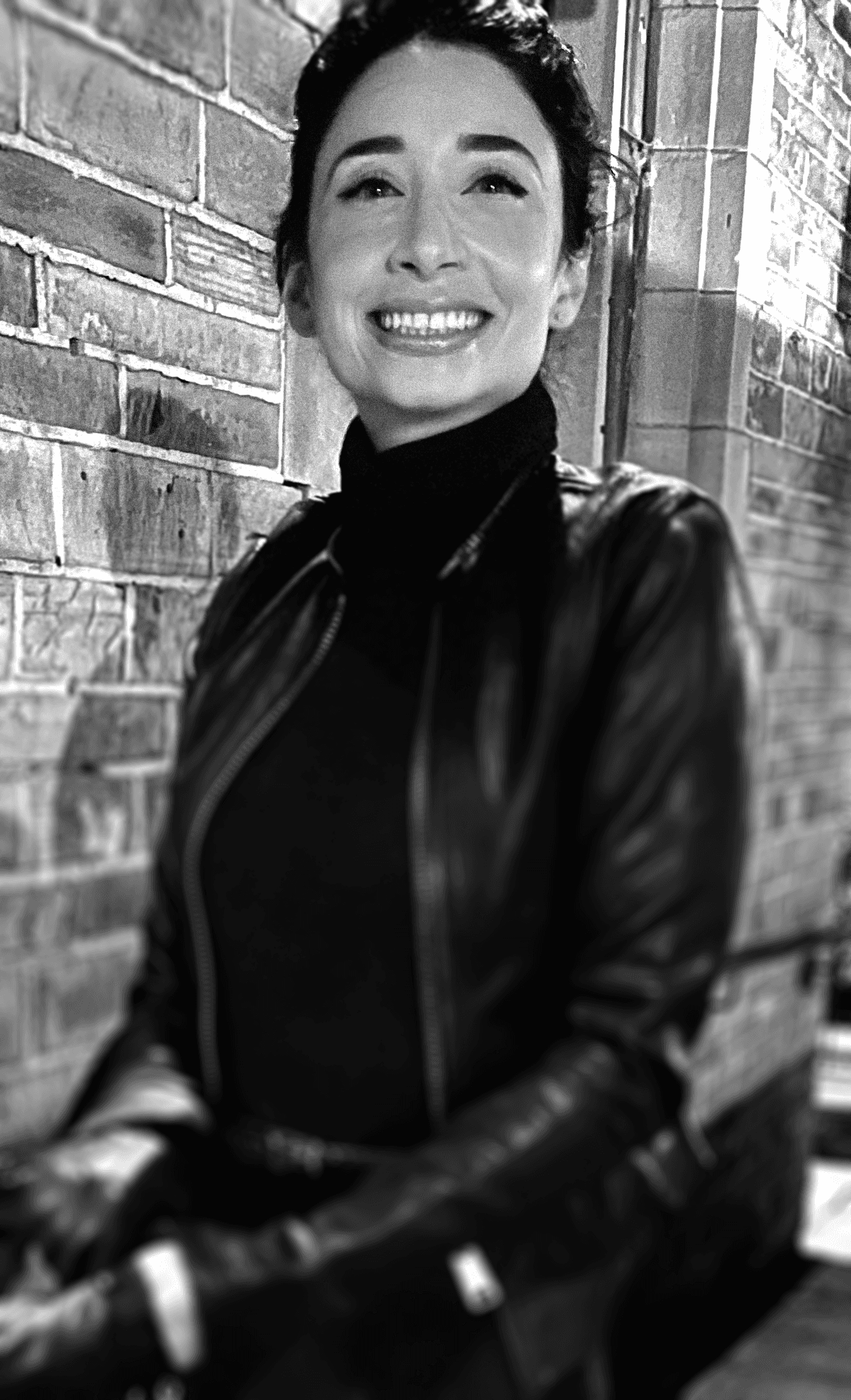 Black and white portrait of a smiling person with curly hair