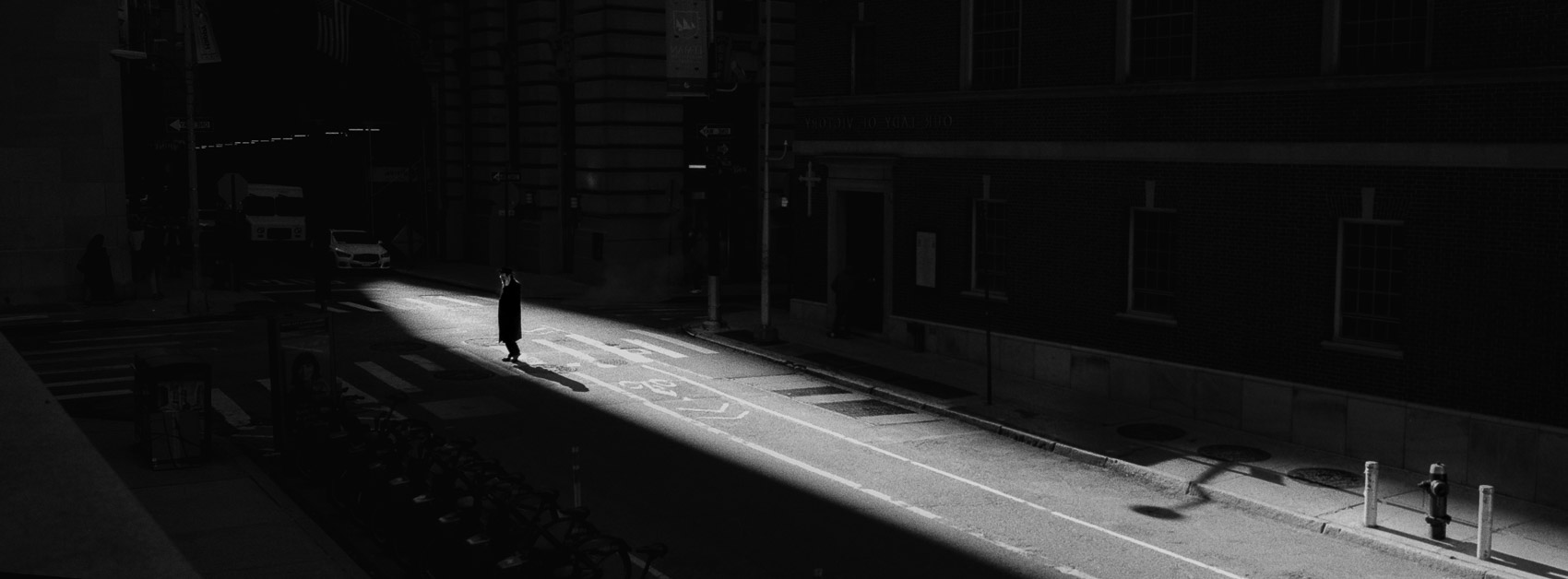 Photographing shadows on film: a man walking in the sun light that came down through to the streets of NYC in between the buildings, with Zone III detail preserved
