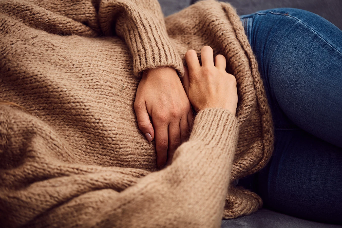 Woman struggling with cramps representing PCOS care - coming soon