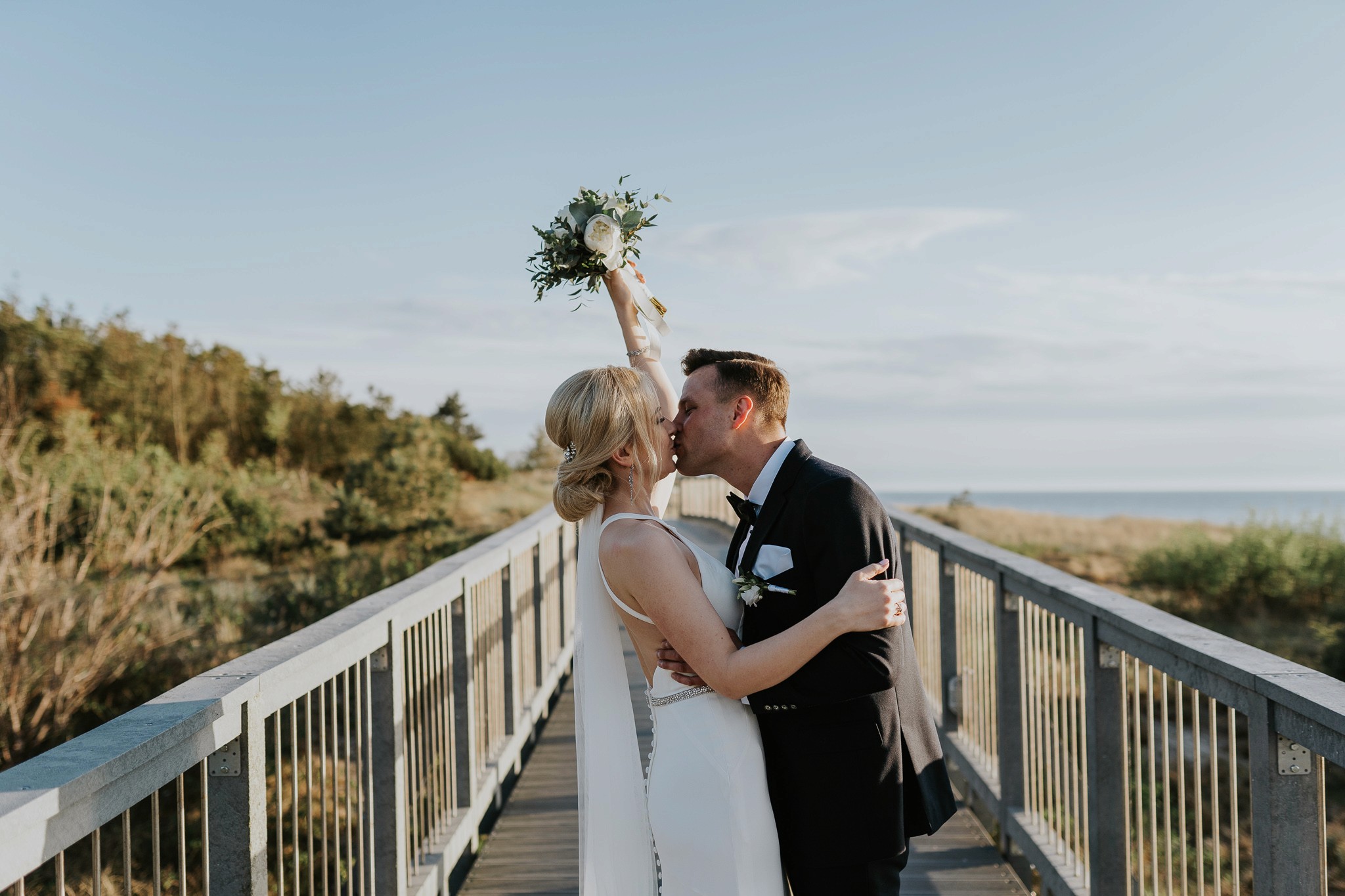 A person with short blonde hair holds a vintage camera.