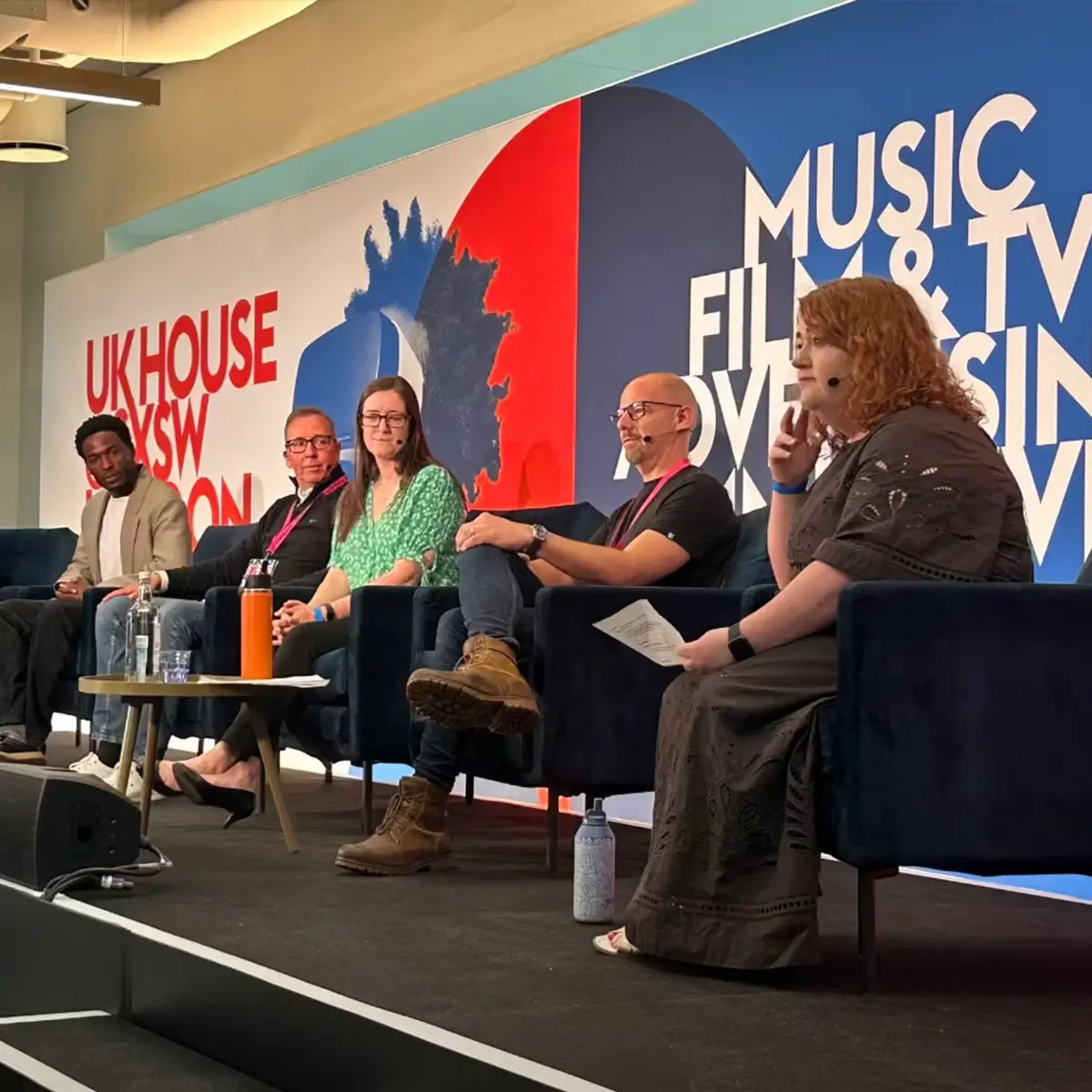 Panel discussion at UK House during SXSW London, featuring speakers from music, healthcare, and technology discussing innovation and wellbeing.