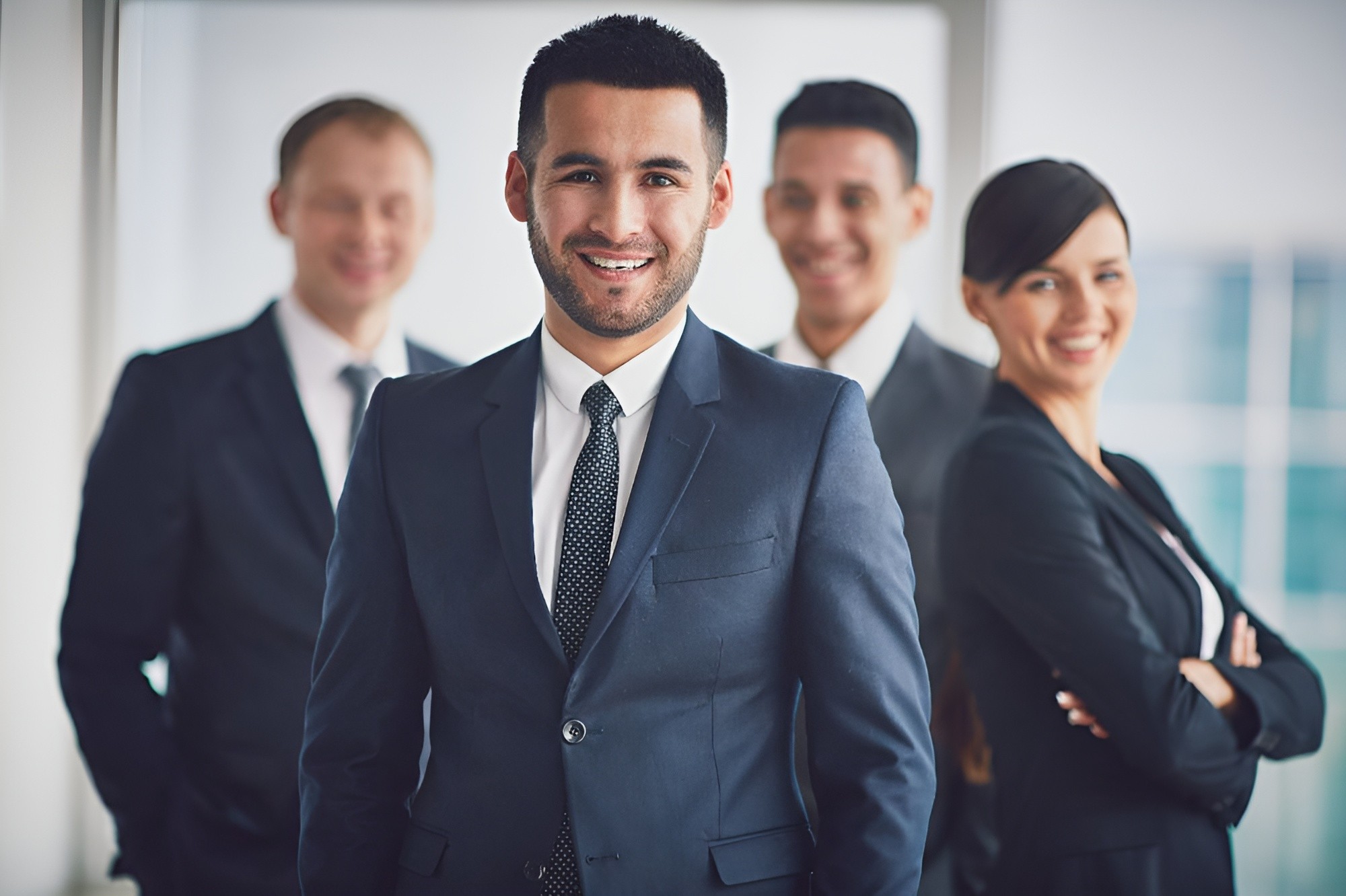 Confident businessman standing with colleagues