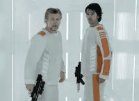 Two prijsoners wearing white and orange jumpsuits holding blasters in a white prison