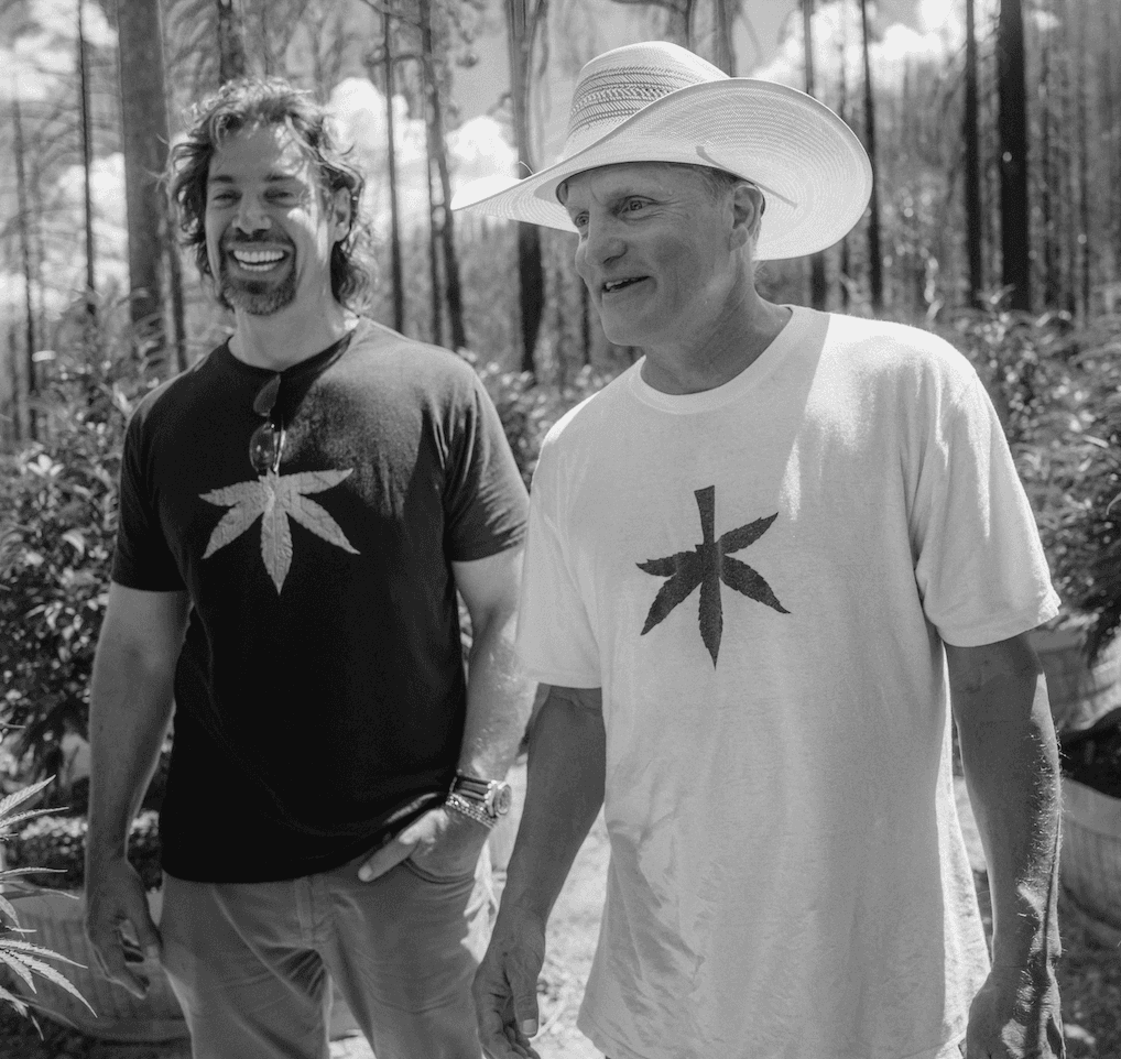 Woody Harrelson talking and laughing with his friend.