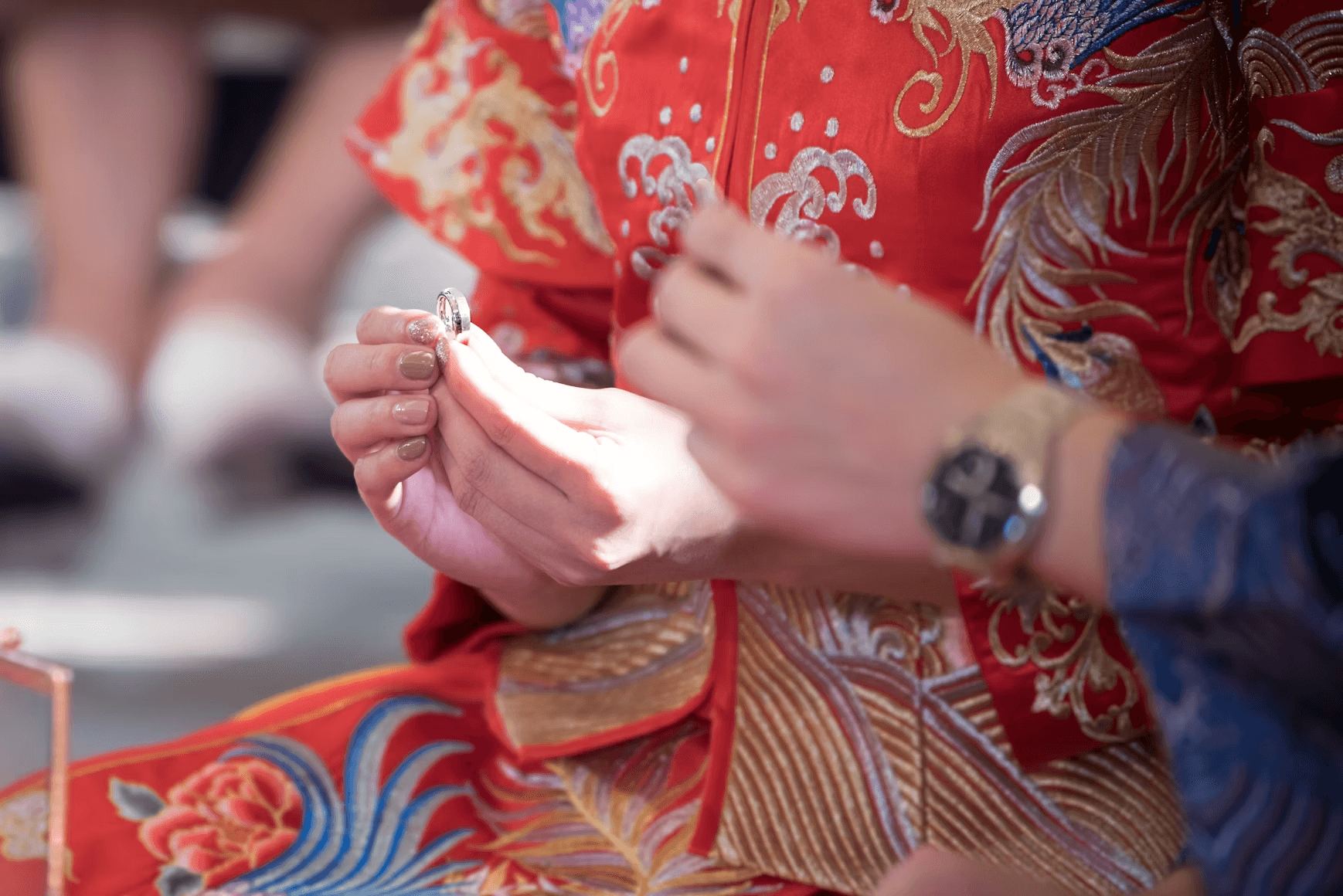 Bride and groom in Chinese wedding dresses were wearing rings for each other