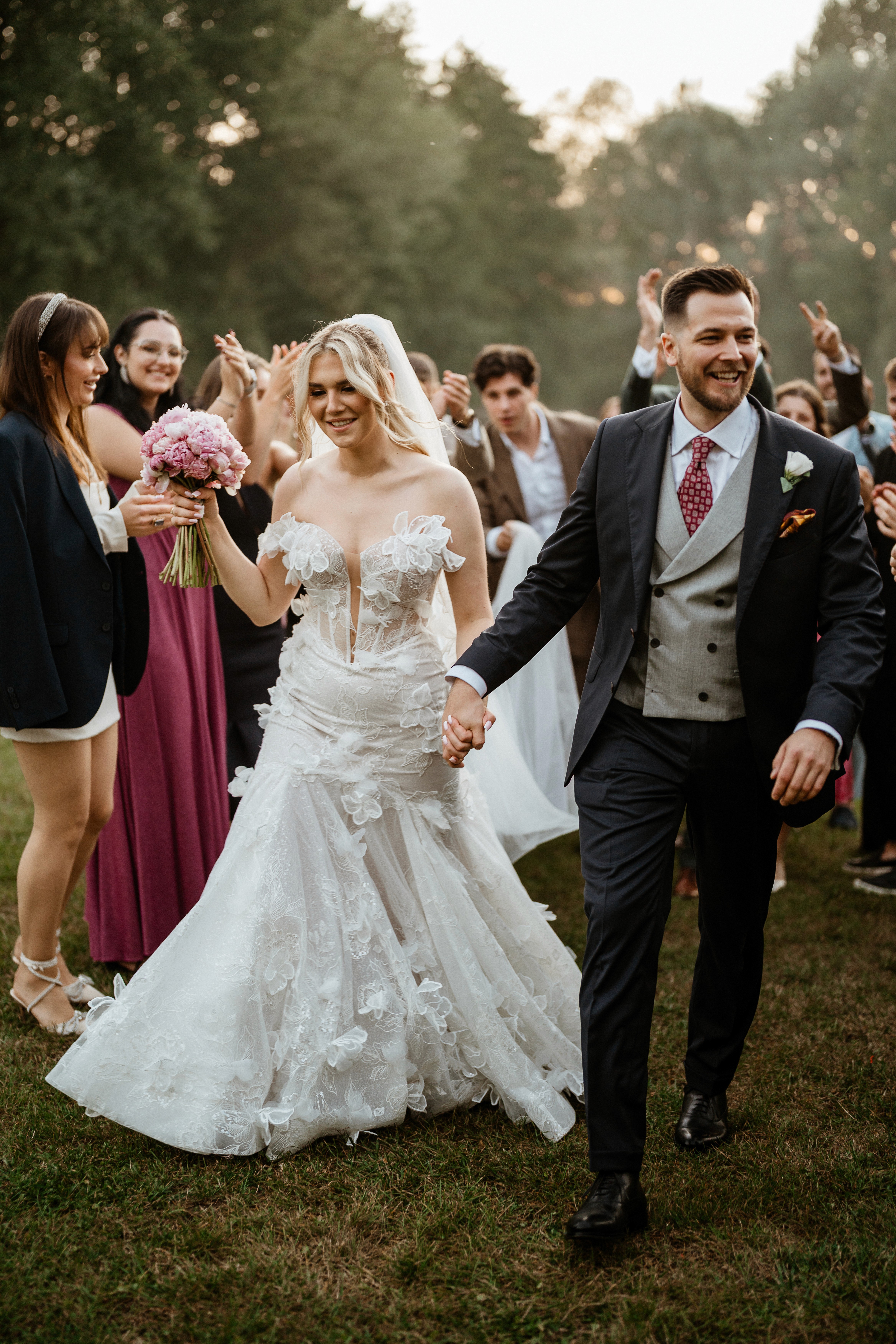 A bride in a lace wedding dress gently holds.